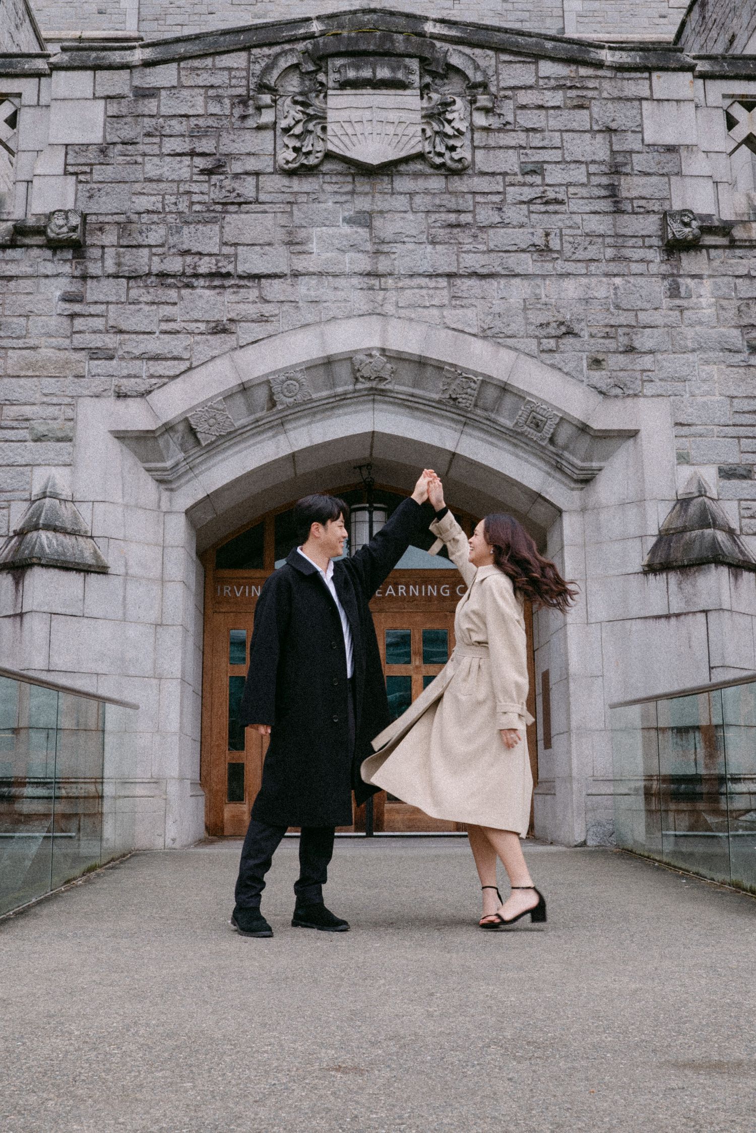 Couple dances in front of UBC Irving. Vancouver engagement by Victor Li Photography.