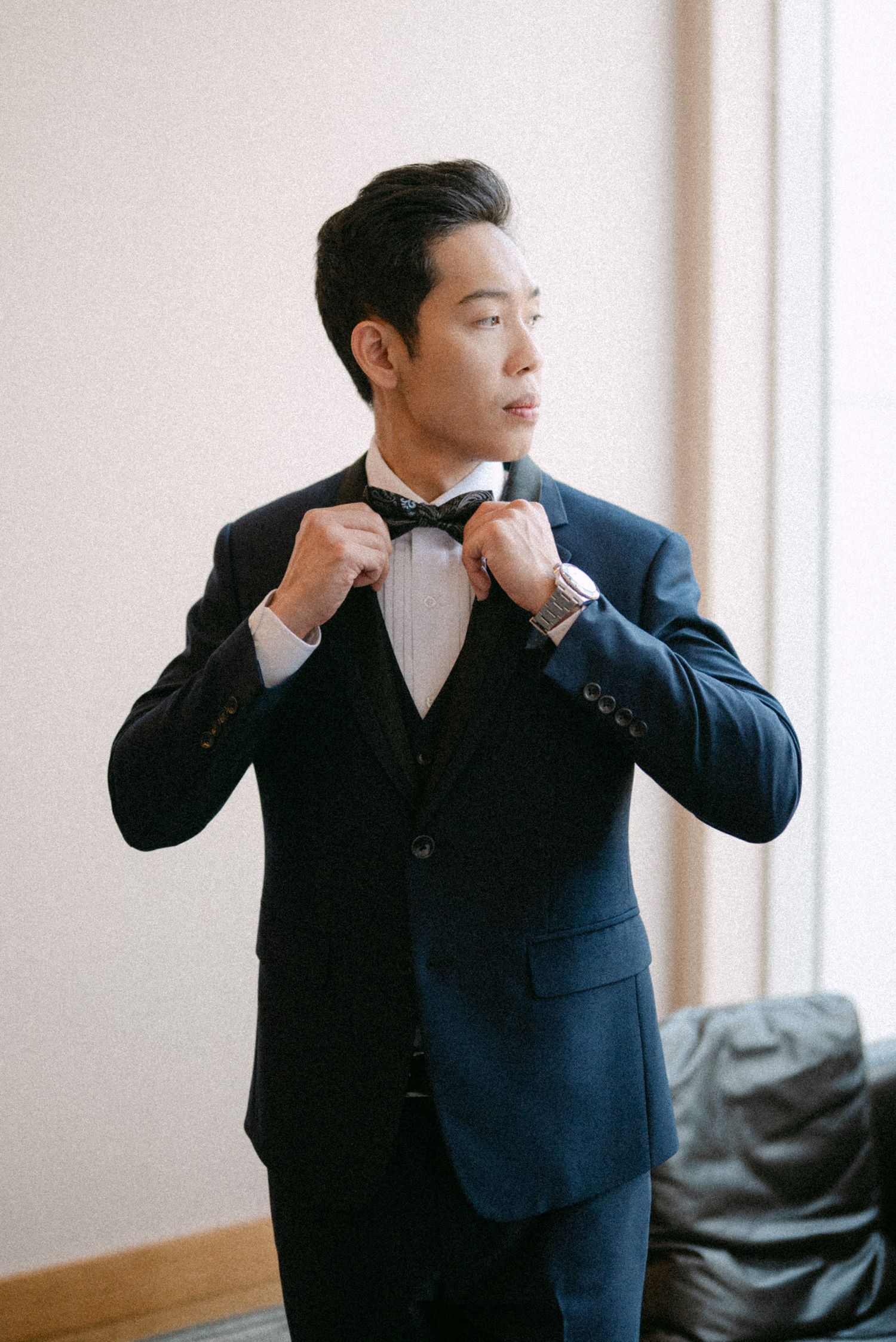 Groom adjusts bowtie. Vancouver wedding by Victor Li Photography.