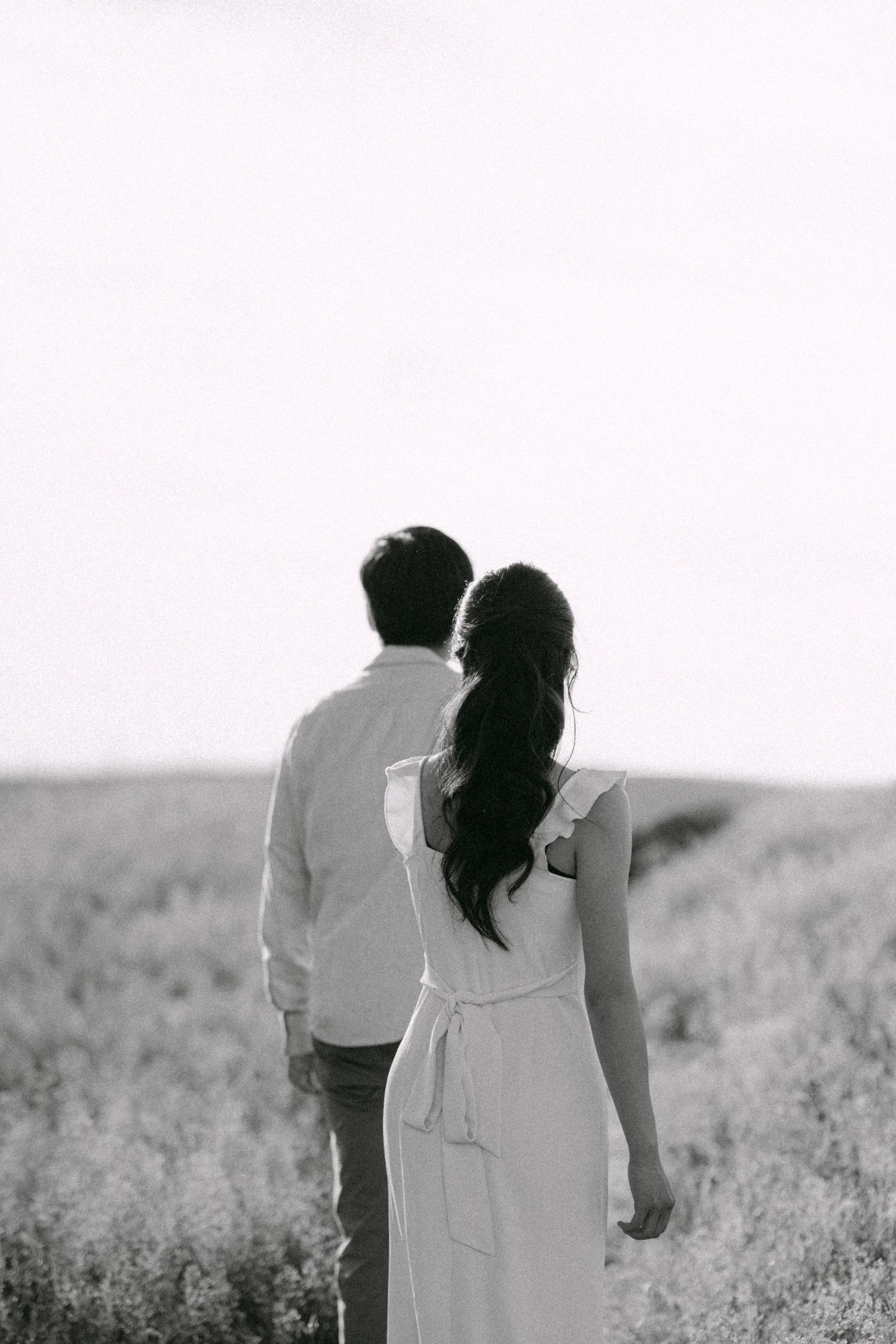 Romantic walk with couple through open field at Terra Nova Park. Vancouver prewedding and engagement by Victor Li Photography.