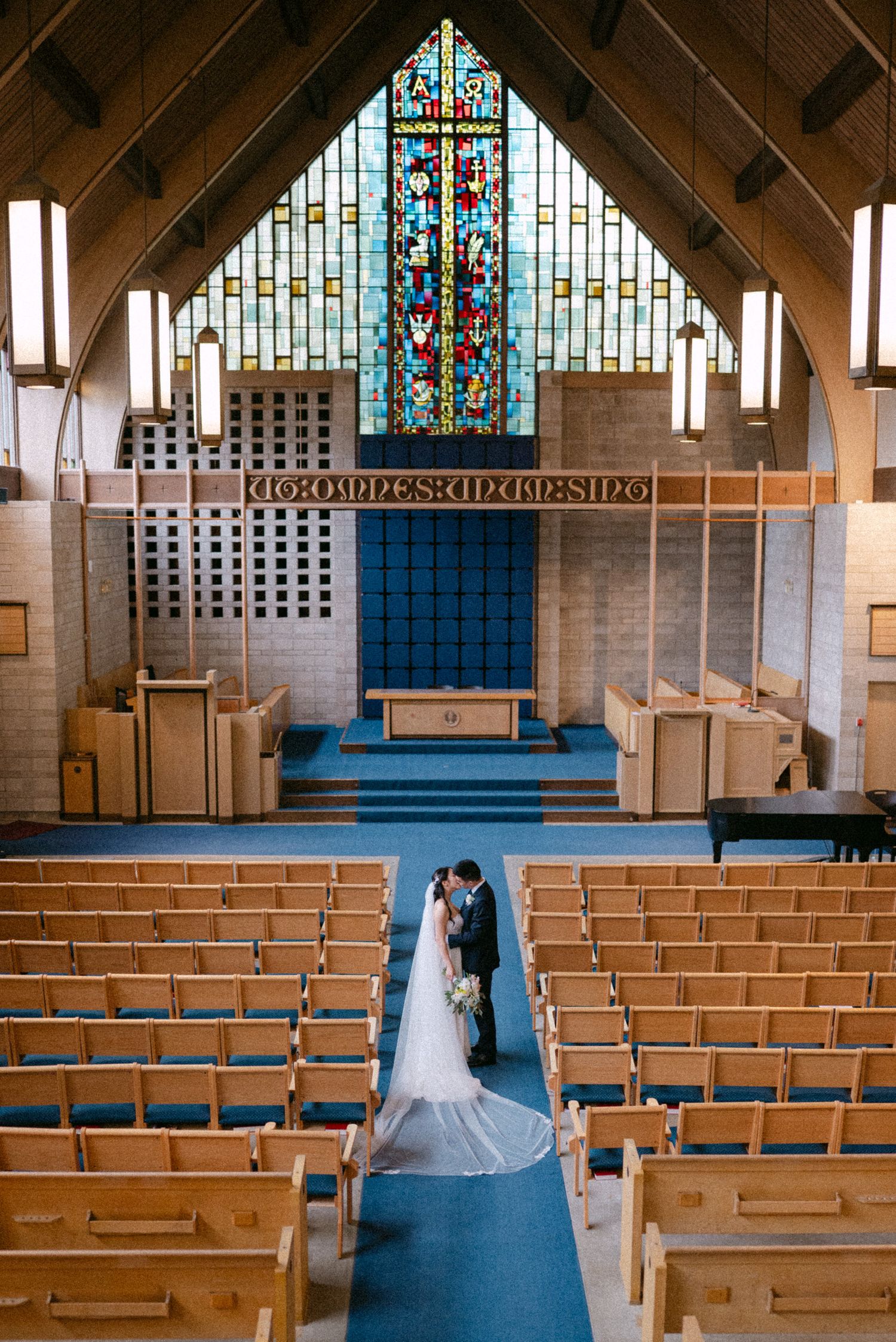 Couple kisses in empty cathedral. Vancouver wedding by Victor Li Photography.