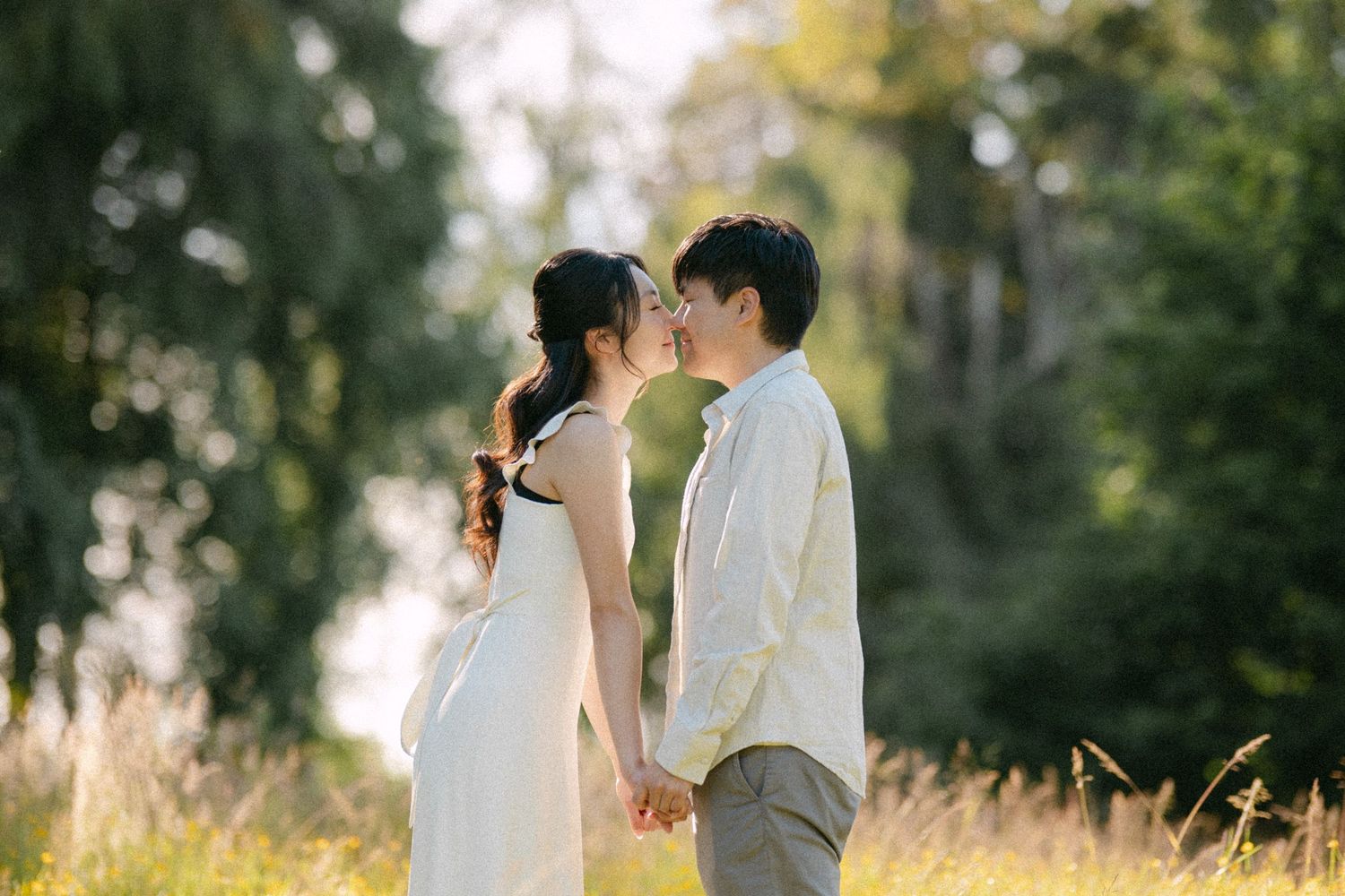 Couple kissing in open field at Terra Nova Park. Vancouver prewedding and engagement by Victor Li Photography.