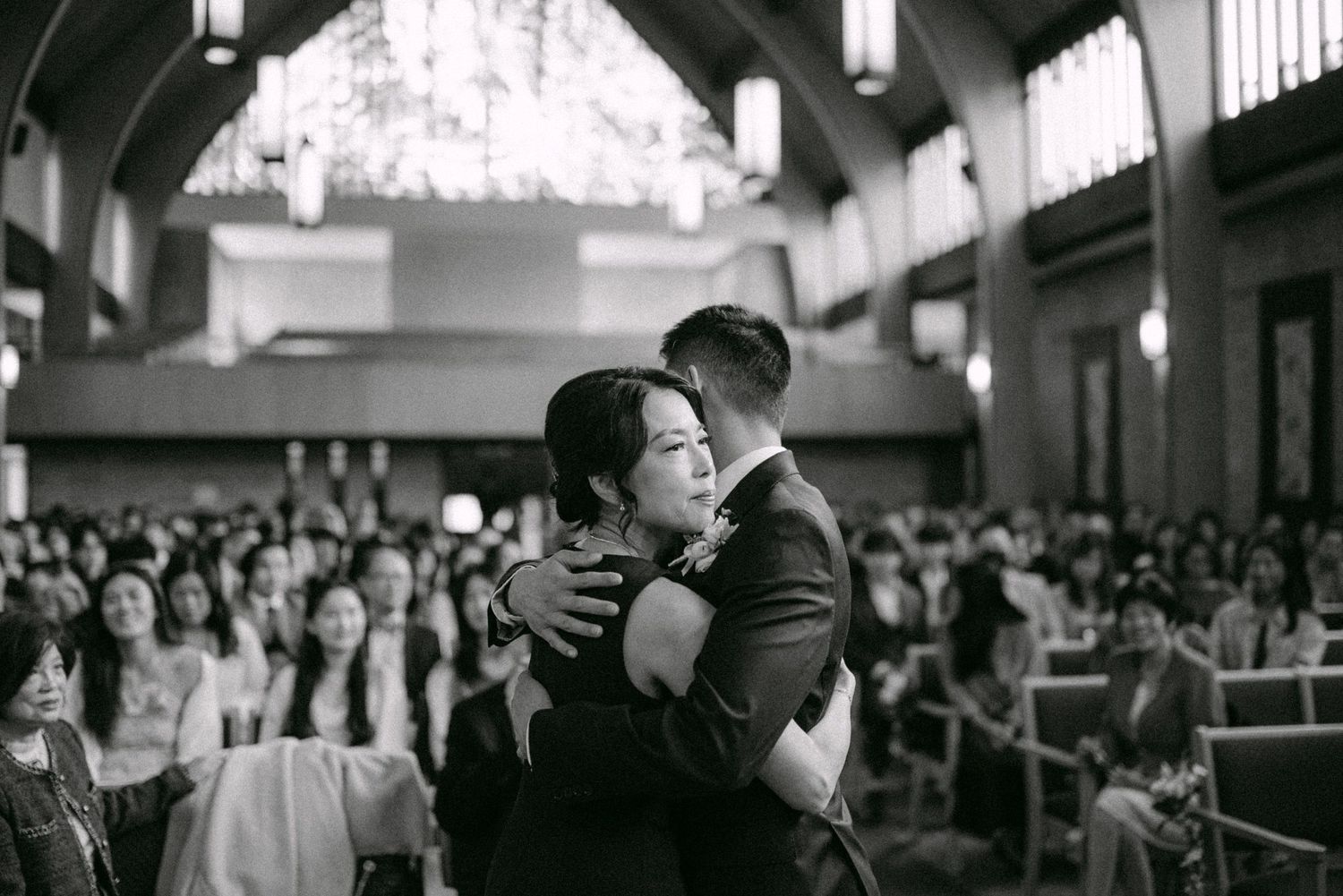 Groom embraces his mother at the ceremony. Vancouver wedding by Victor Li Photography.
