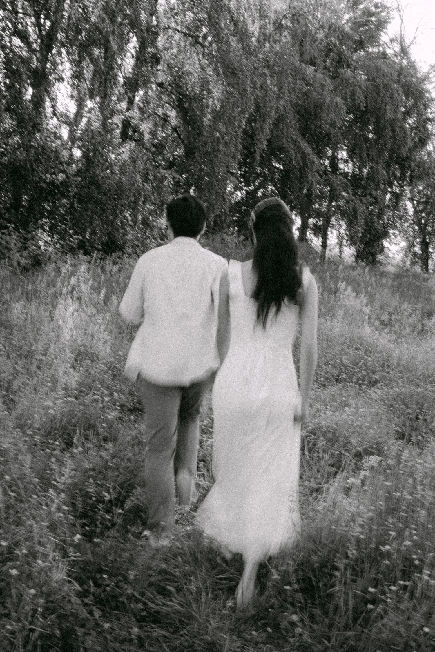 Couple running through open field at Terra Nova Park. Vancouver prewedding and engagement by Victor Li Photography.