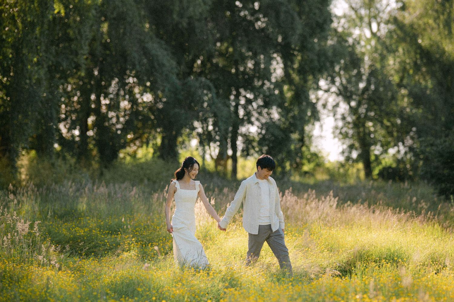 Couple walking through open field at Terra Nova Park. Vancouver prewedding and engagement by Victor Li Photography.