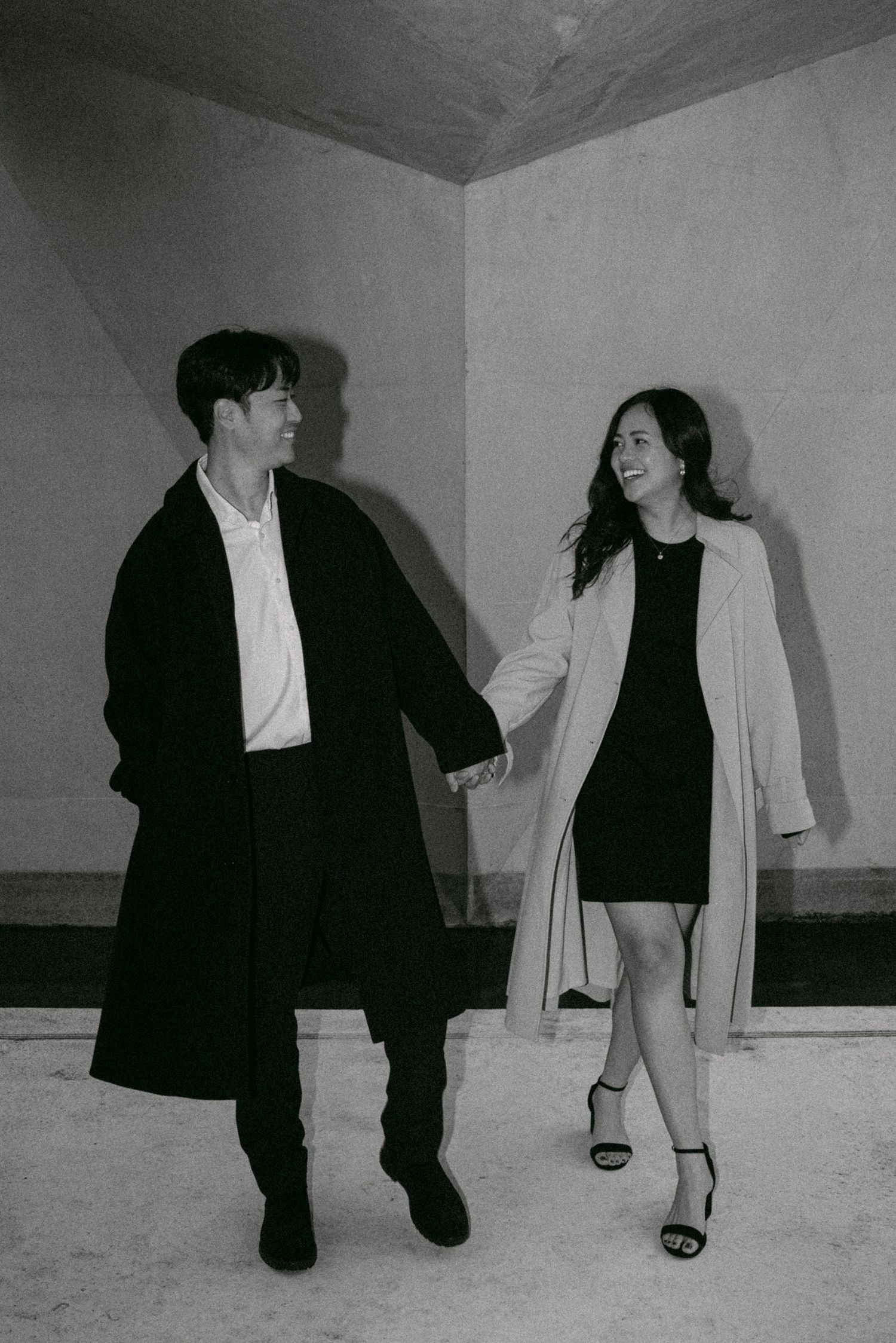 Couple walking along structure at UBC Buchanan Courtyard. Vancouver engagement by Victor Li Photography.