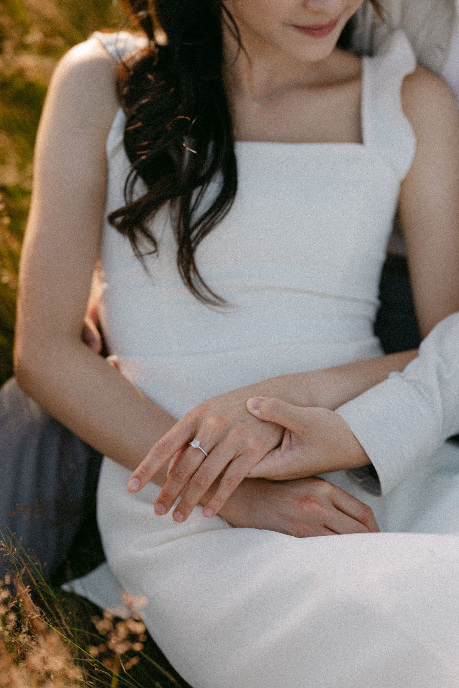 Close-up of engagement ring in open fields of Terra Nova Park. Vancouver prewedding and engagement by Victor Li Photography.