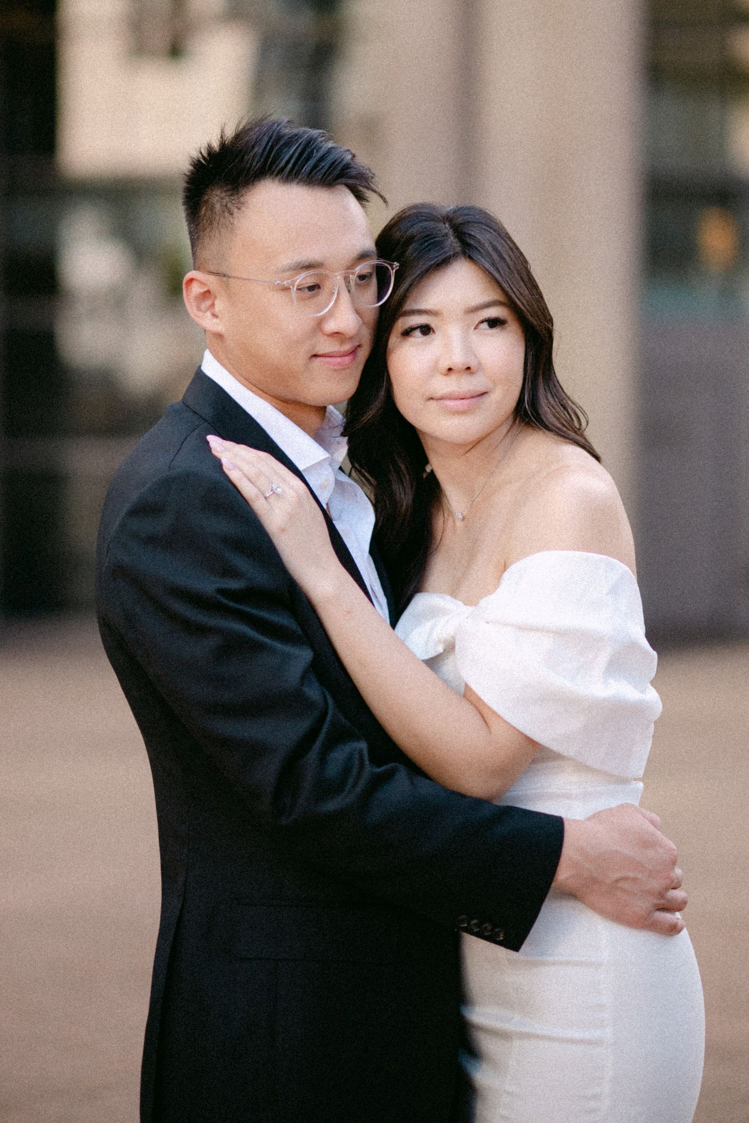 Couple embraces in front of Vancouver Public Library. Vancouver prewedding and engagement by Victor Li Photography.