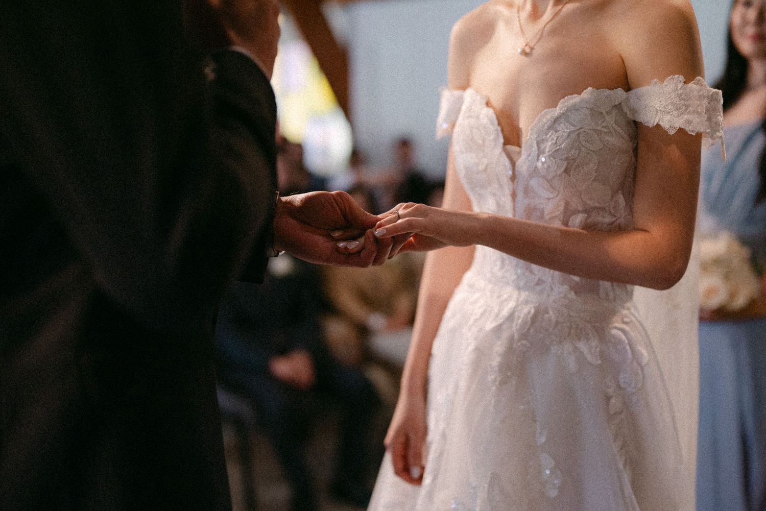 Close-up of groom putting ring on bride. Vancouver wedding by Victor Li Photography.