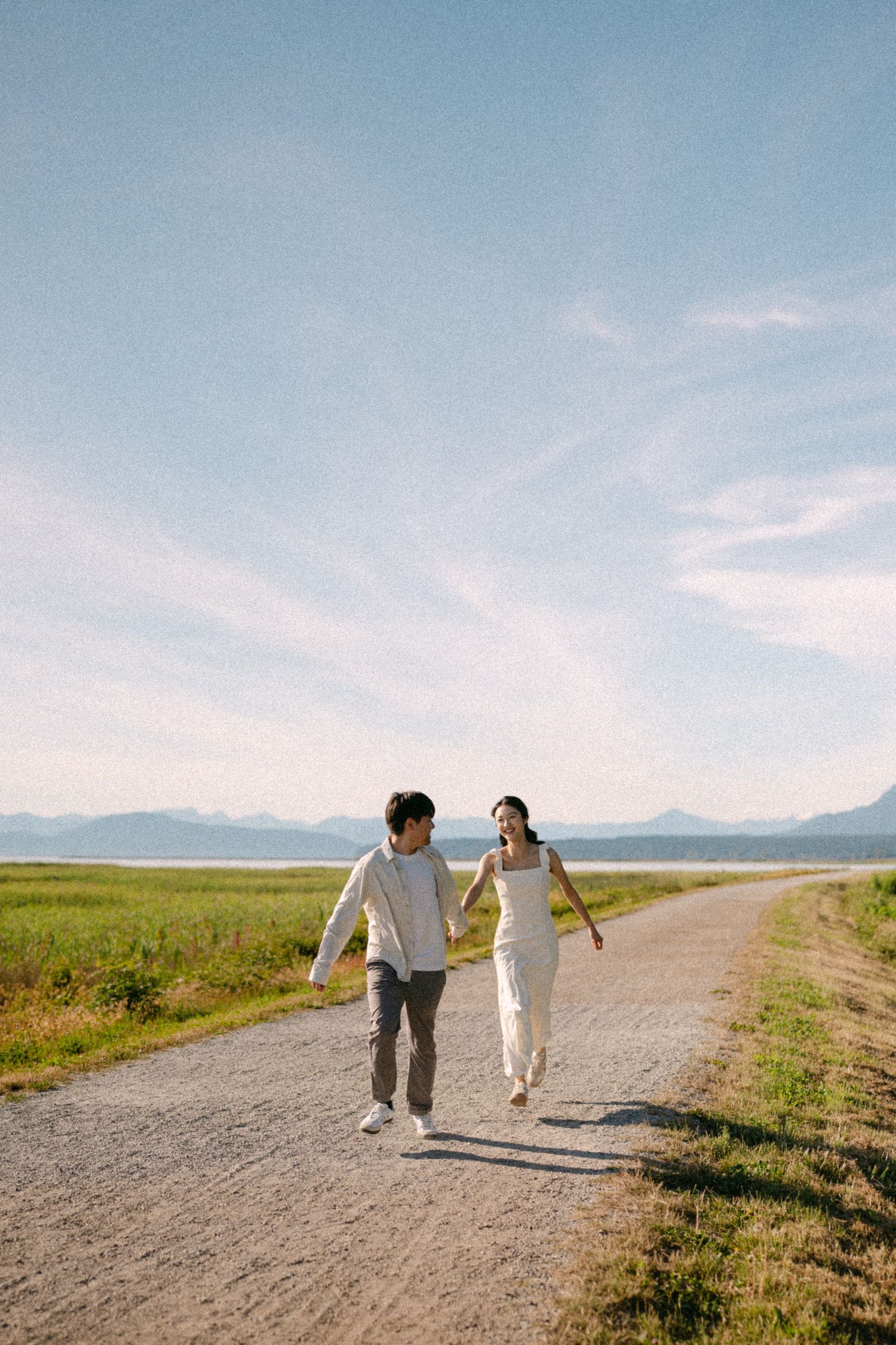 Couple running along path at Terra Nova Park. Vancouver prewedding and engagement by Victor Li Photography.