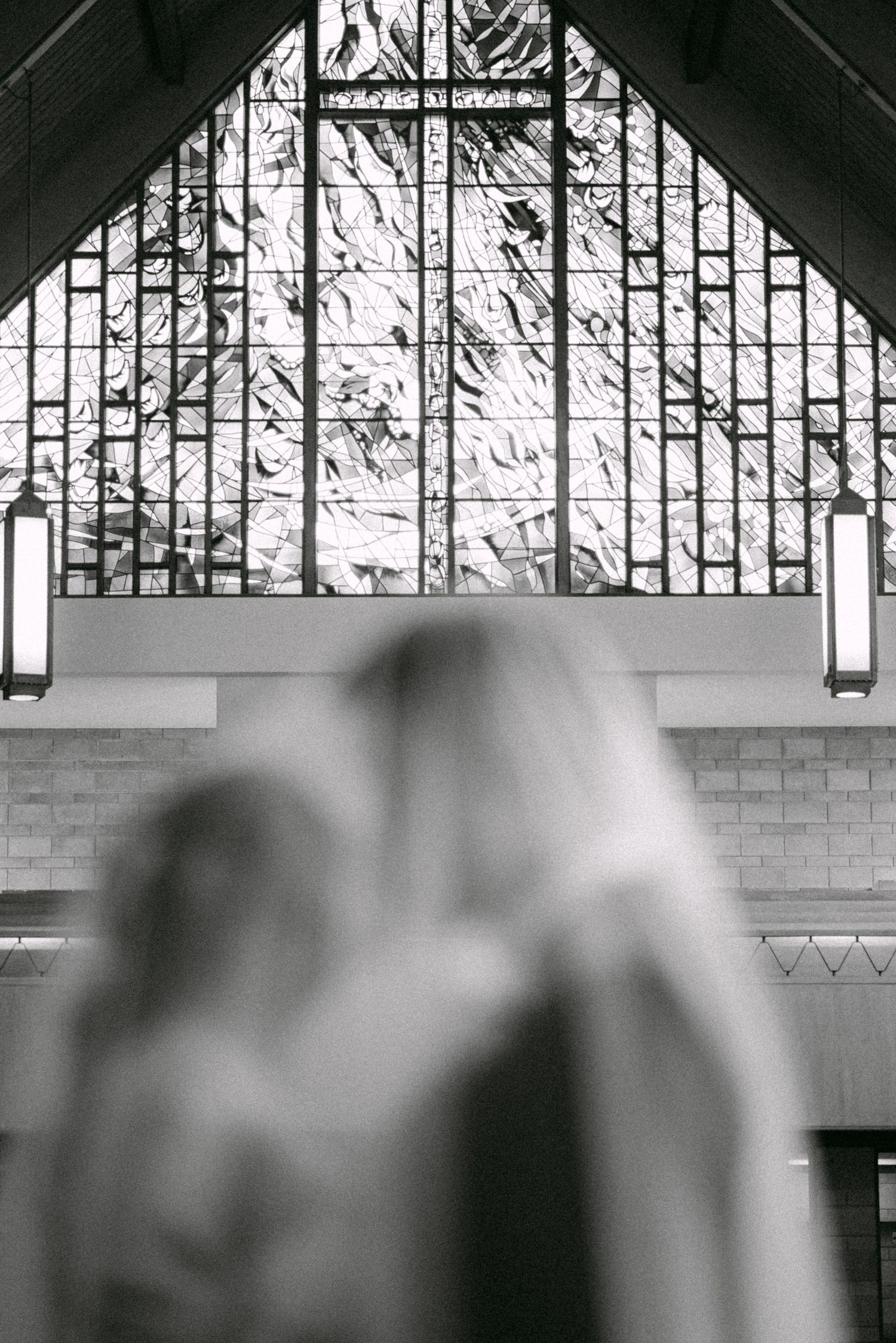 Couple kisses under veil with stained glass background. Vancouver wedding by Victor Li Photography.