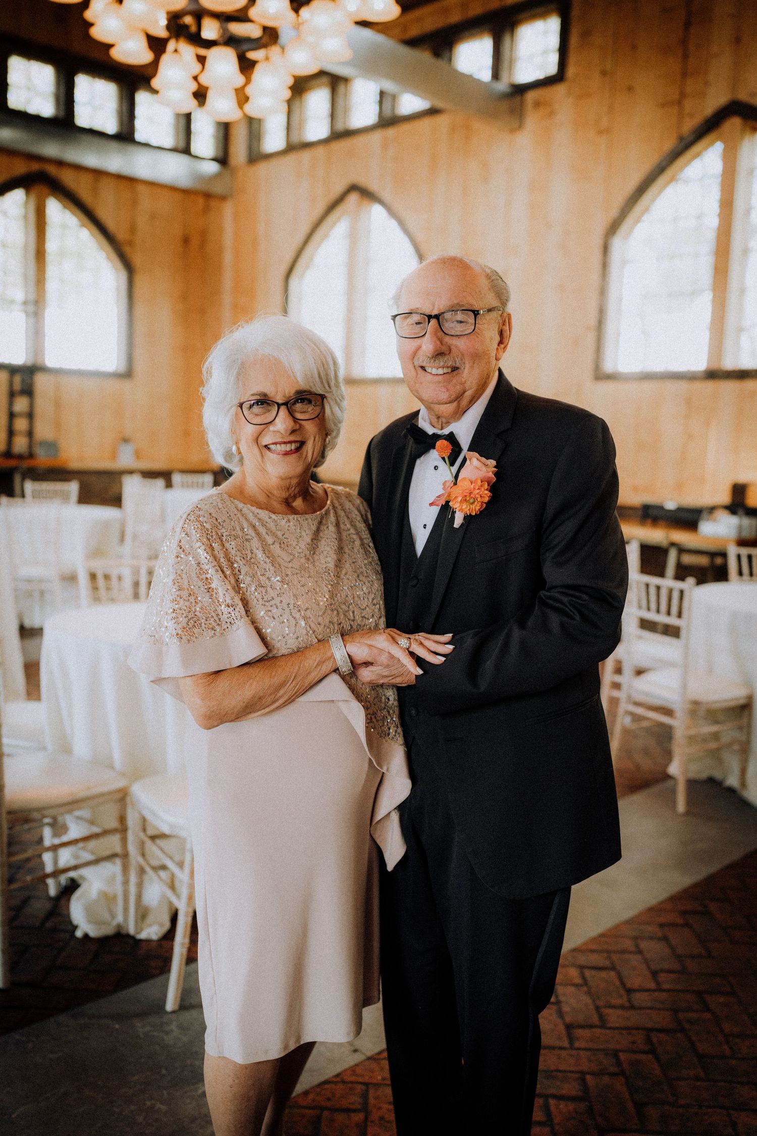 Elegant older couple in formal attire pose together in a beautiful church venue.