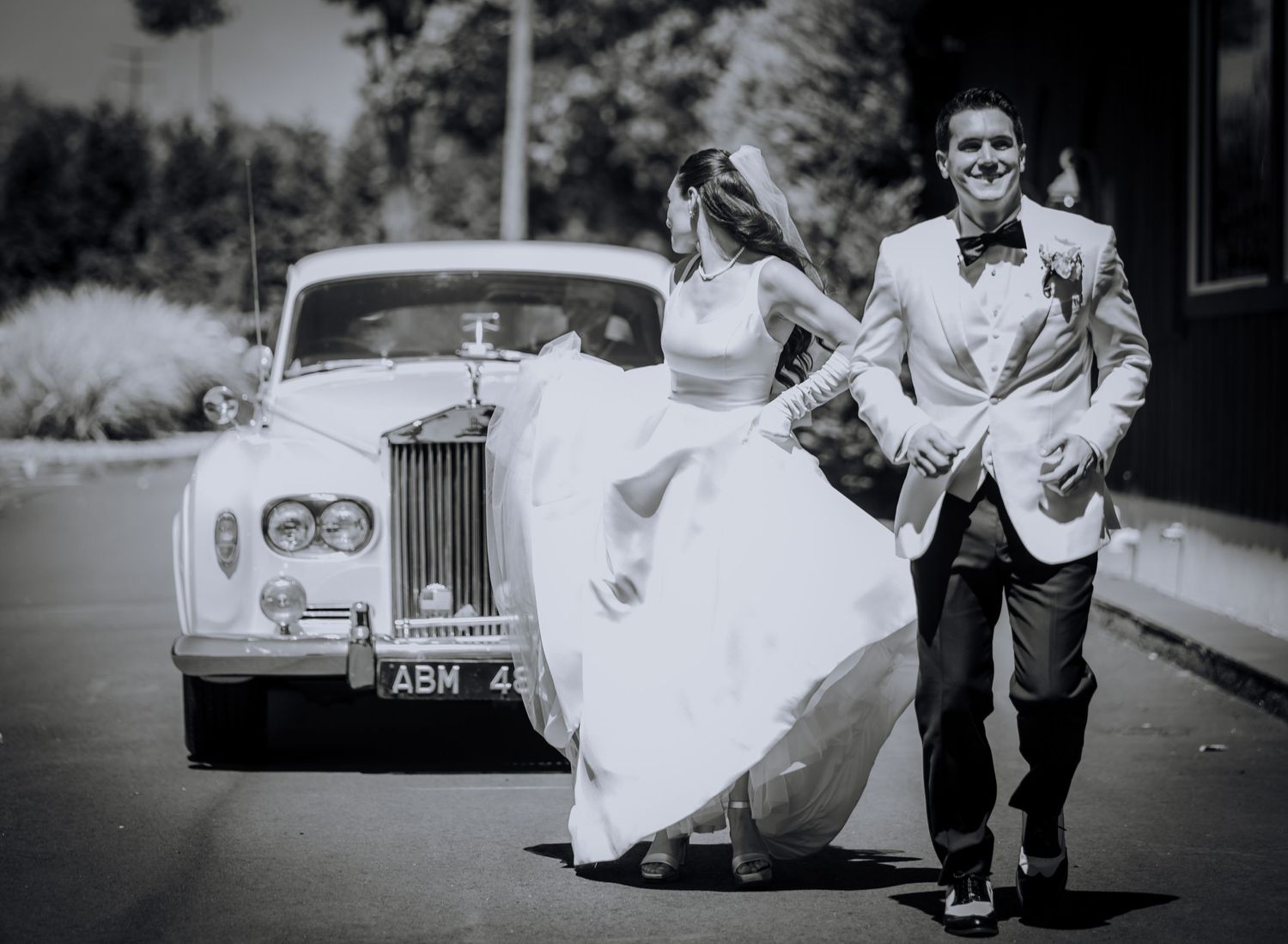Vintage-style black and white photos of a couple running playfully near a classic car.