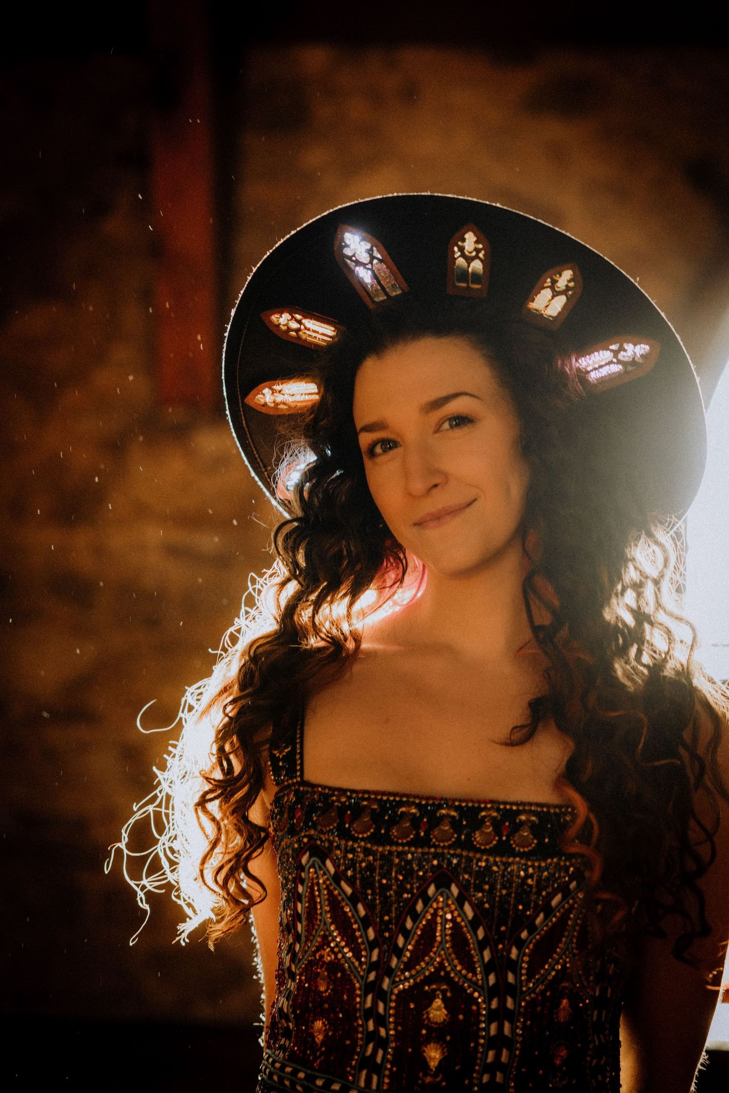 Artistic portrait with backlighting and a black hat creating a dramatic silhouette effect.