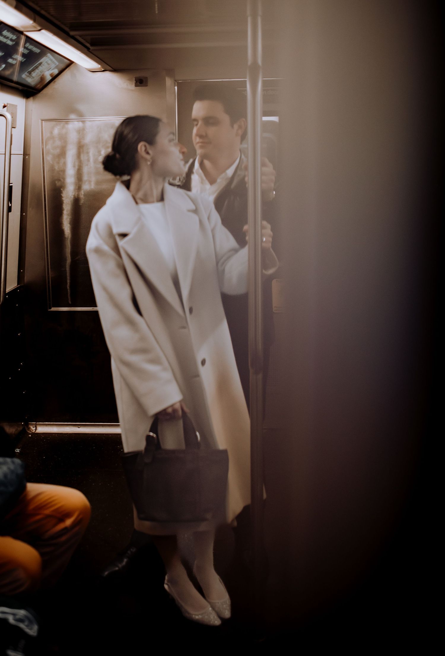 Intimate moment captured in a dimly lit subway car with soft vintage tones.