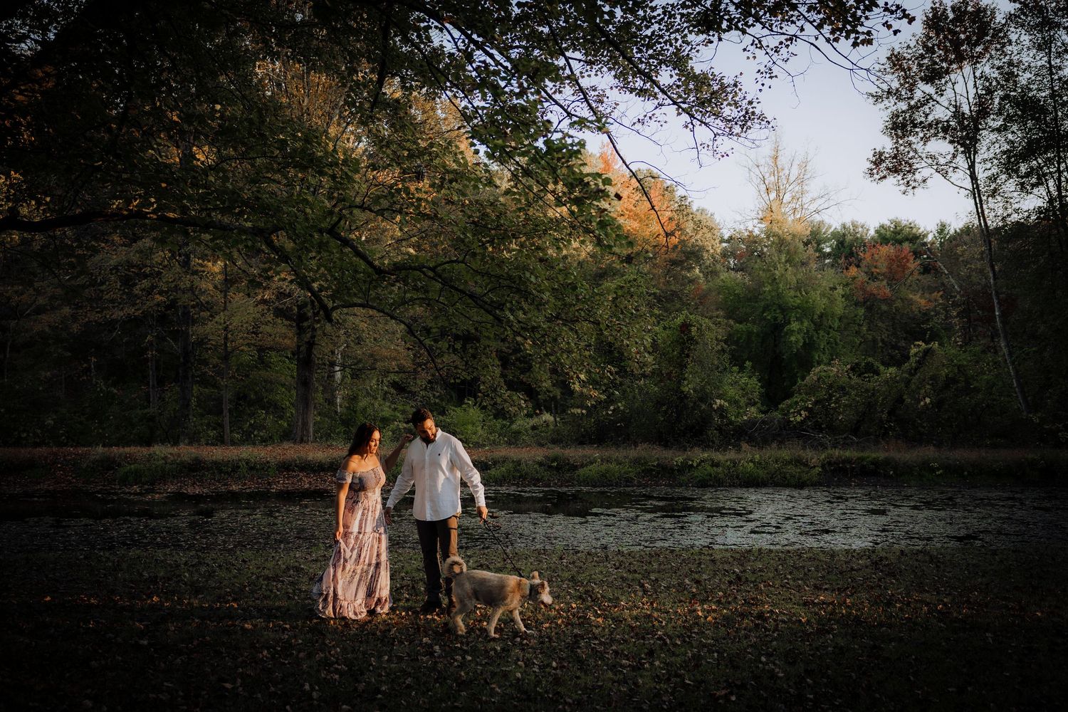 Scenic outdoor engagement photo session in a natural wooded setting at sunset.