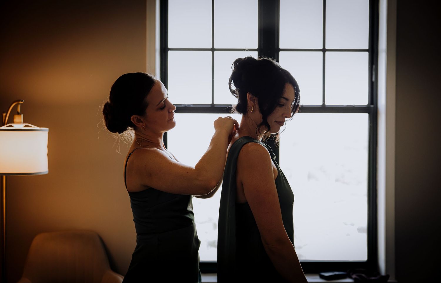Silhouettes against large windows creating dramatic wedding day portraits.