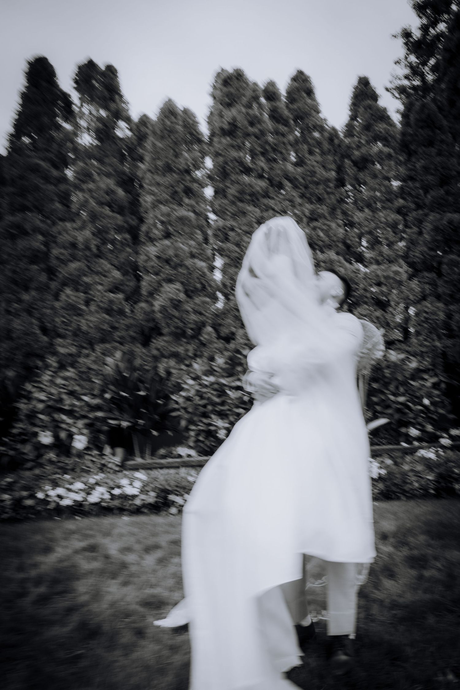 Artistic black and white photo sequence showing ethereal movement of white fabric against a dark forest background.