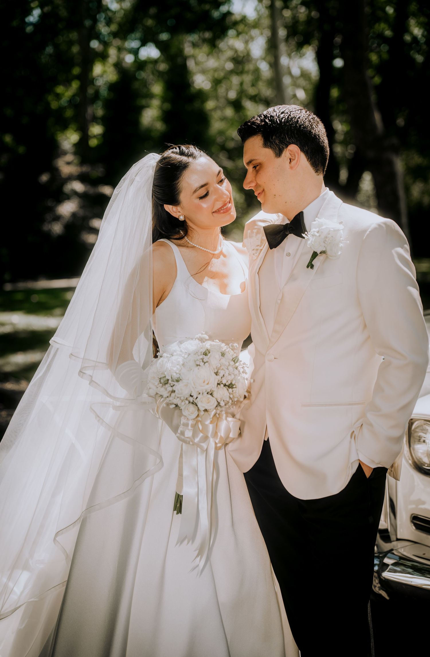 Romantic wedding portraits showing tender moments between newlyweds in white attire.