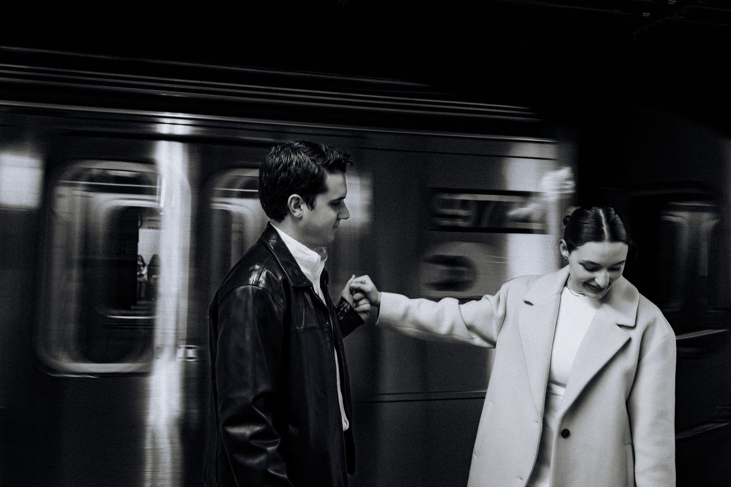 Black and white photo of a wedding party walking down a subway platform.