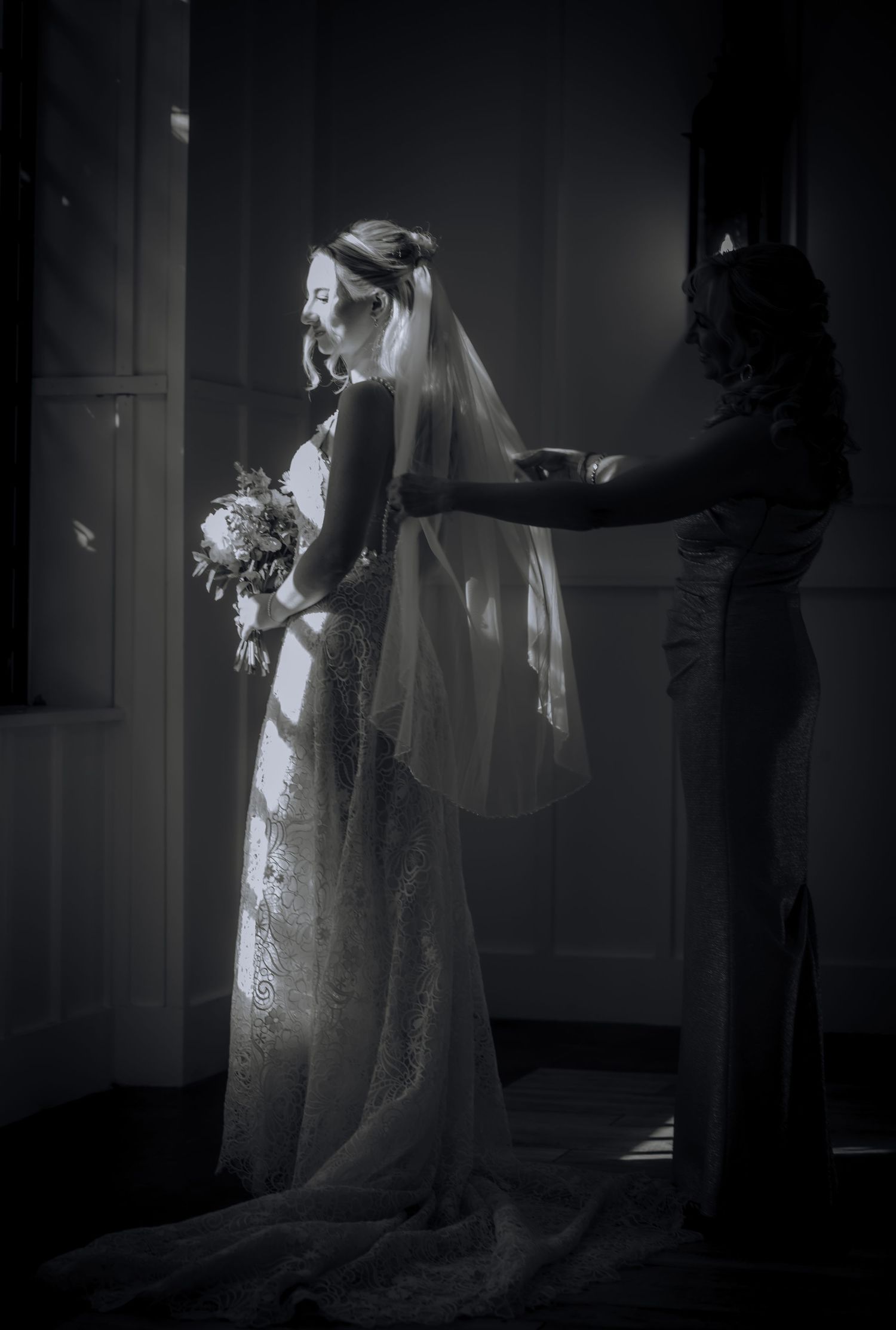 Dramatic black and white photos show a figure in a flowing white dress and veil creating ethereal silhouettes in a dark room.