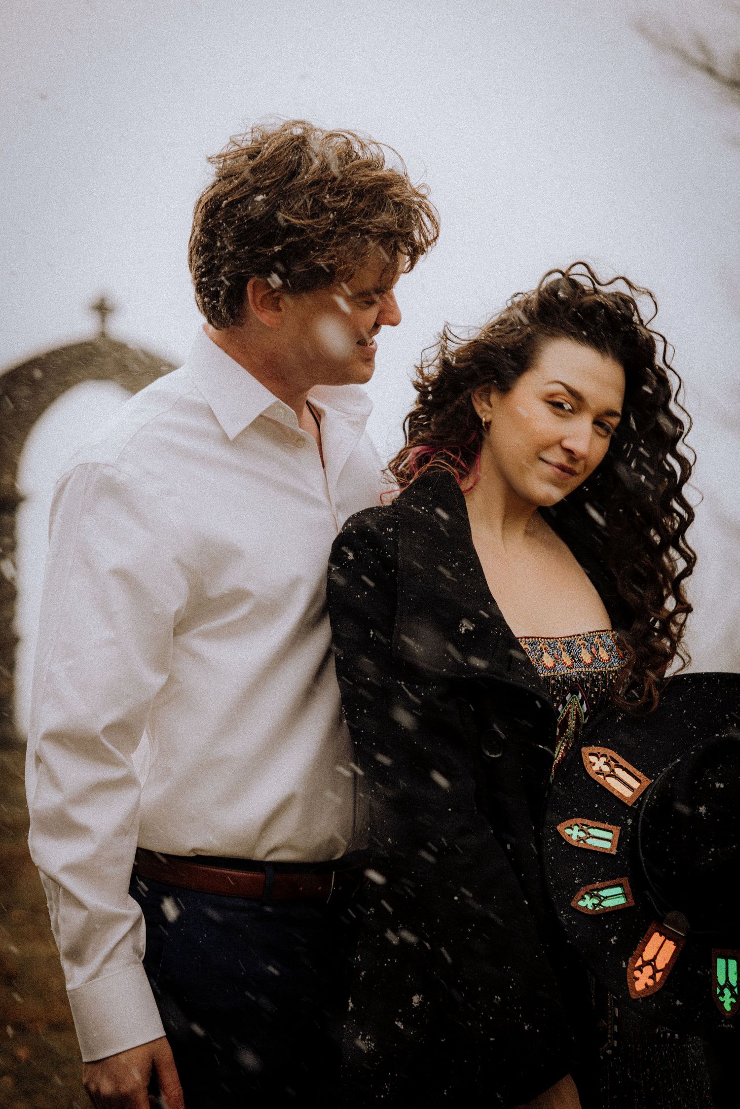 A romantic winter scene with a couple in contrasting black and white outfits.