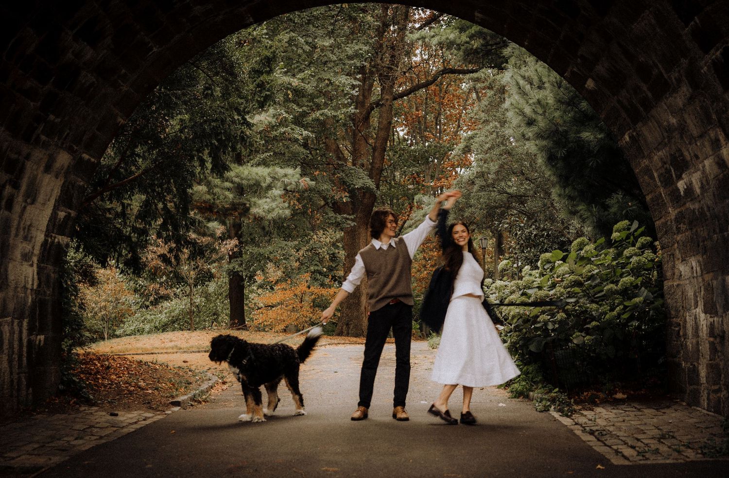 A panoramic view of a romantic autumn forest path with fallen leaves and natural lighting.