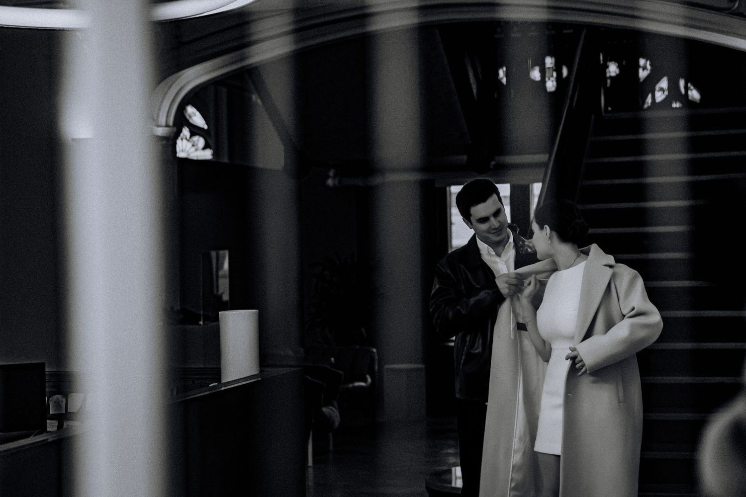 A romantic scene captured through architectural elements in dramatic lighting.