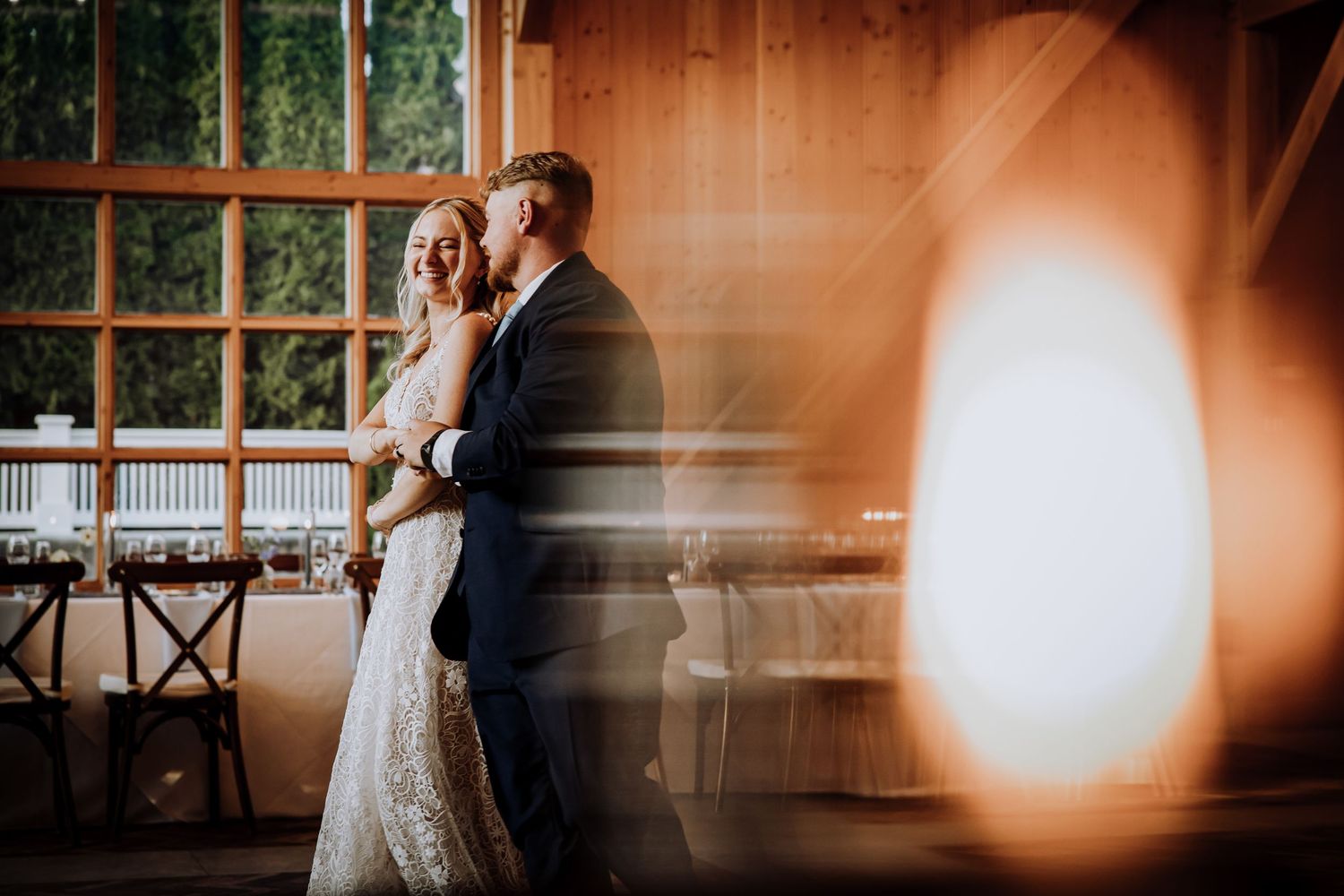 A wedding reception venue with warm lighting and rustic wooden details.