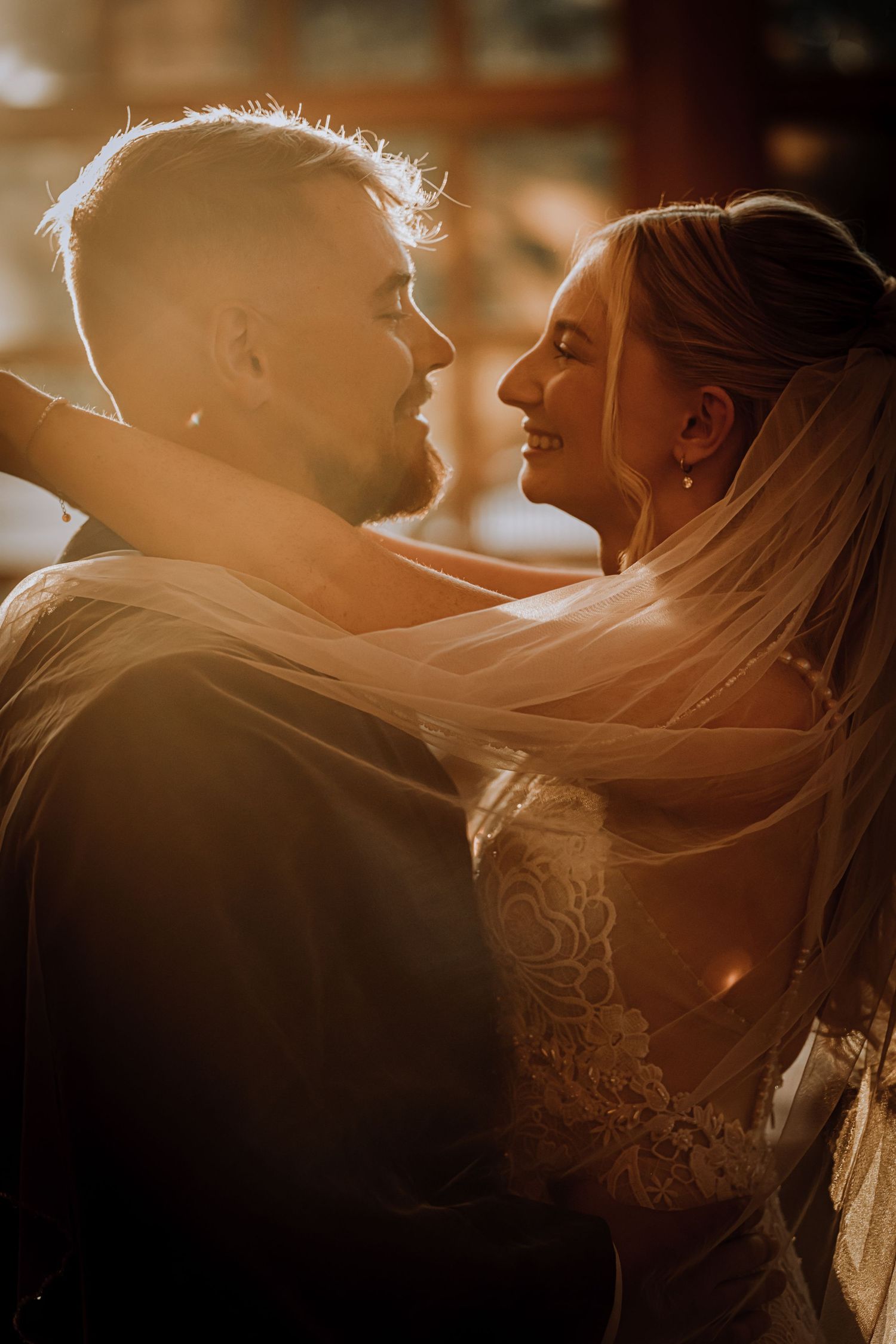 A romantic backlit silhouette of a couple in warm golden light.