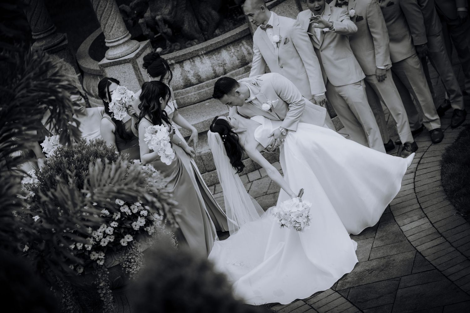 Elegant wedding ceremony setup with white floral arrangements and decorative elements along an outdoor path.