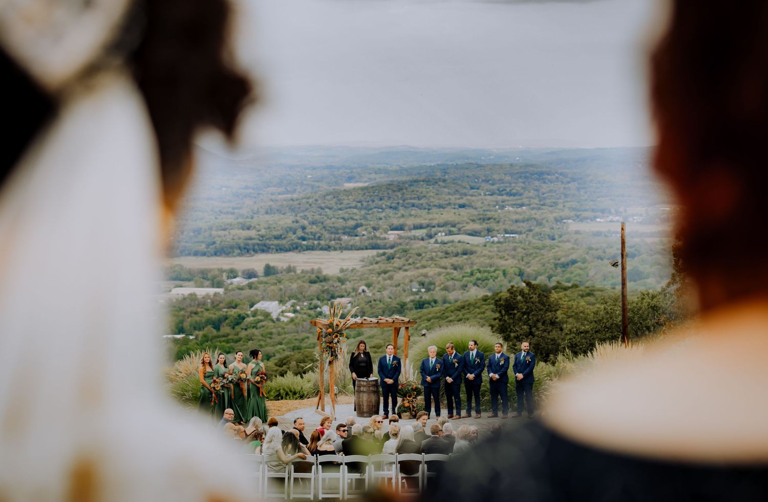 Panoramic view of wedding ceremony setup with mountain landscape in background.