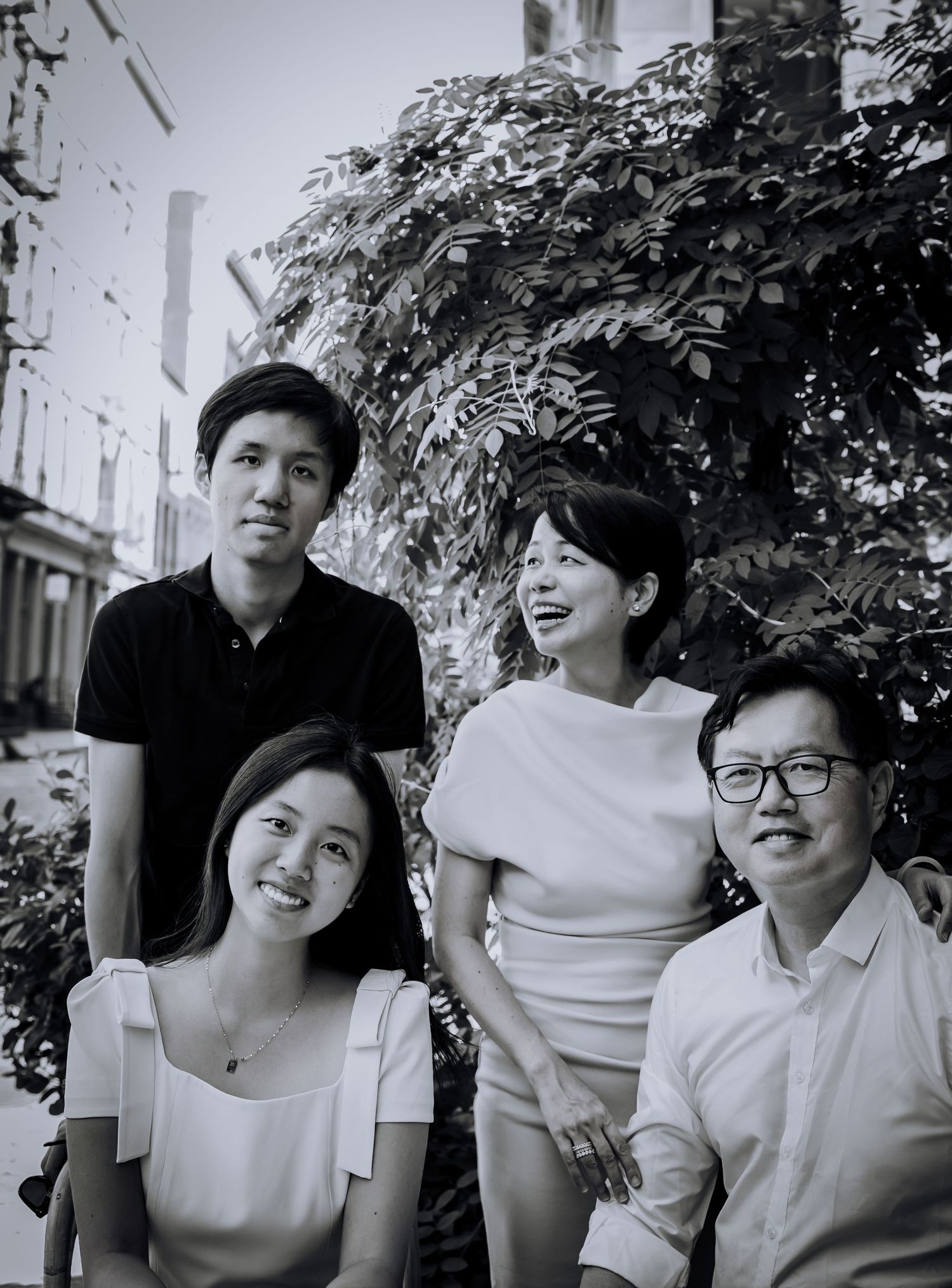 Group in white outfits laughing together during casual outdoor photoshoot.