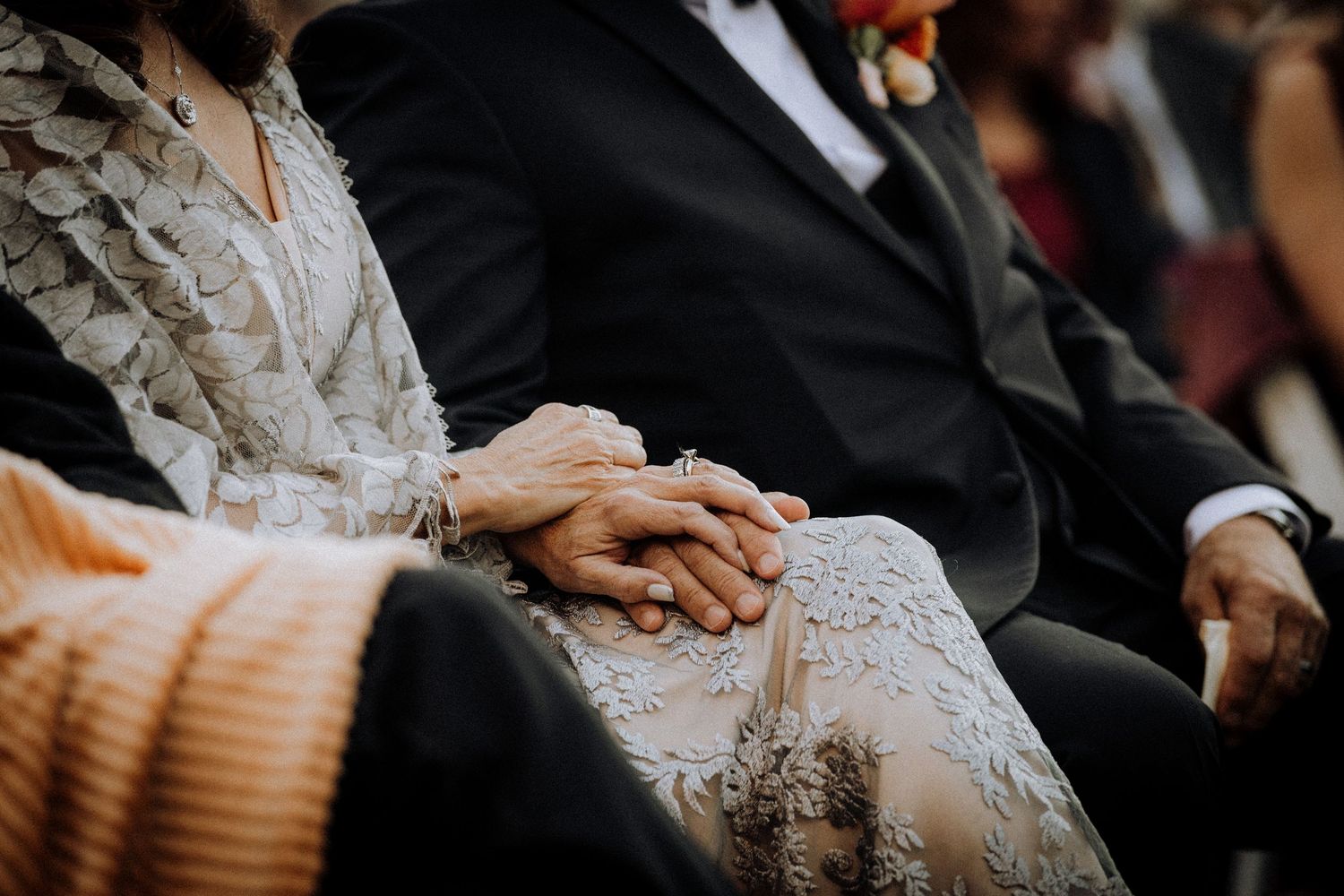 Wedding ceremony guests seated in formal attire during an elegant outdoor event.