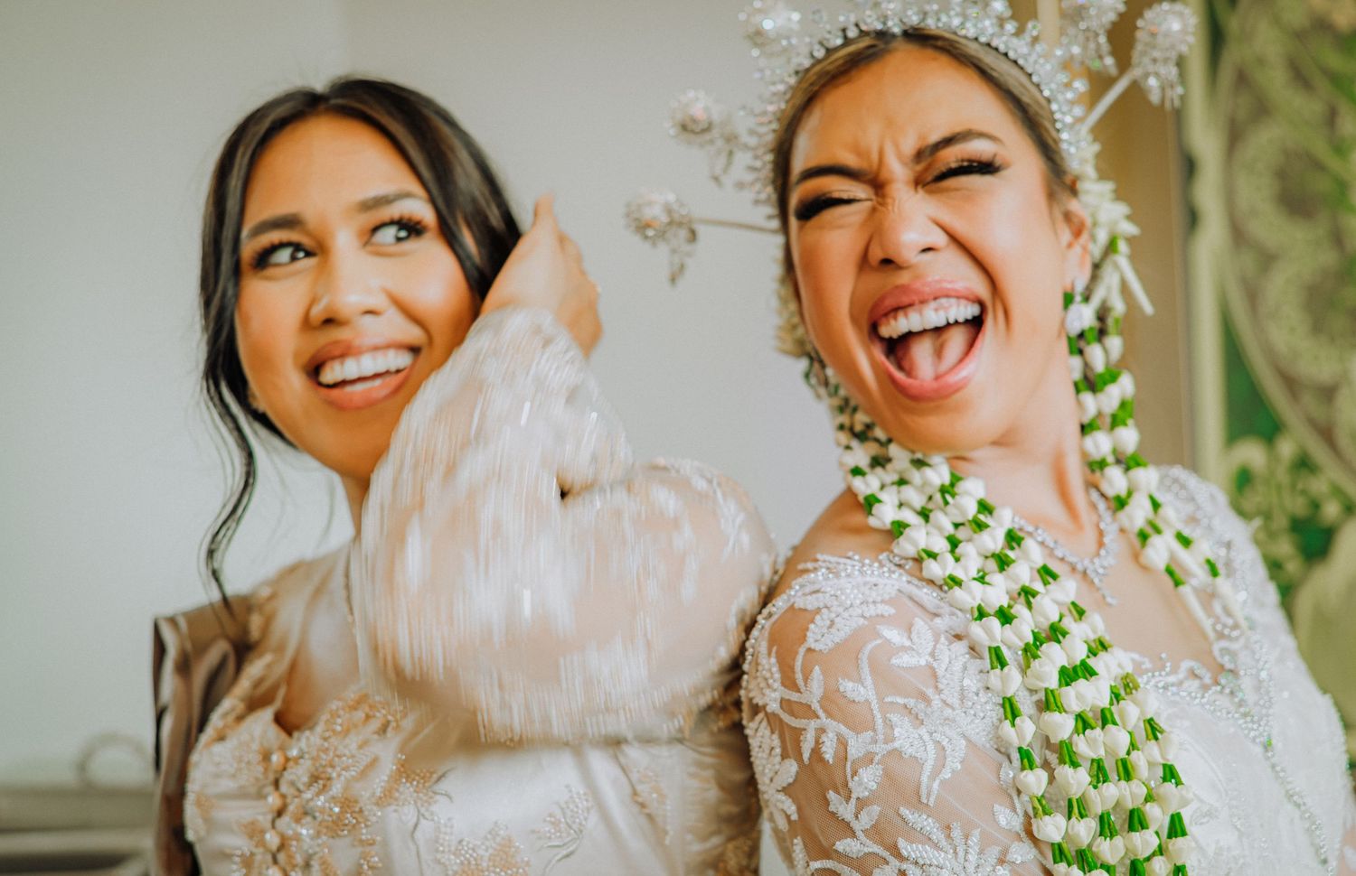 Bride wearing traditional lace veil and wedding dress poses for a series of joyful candid portraits.