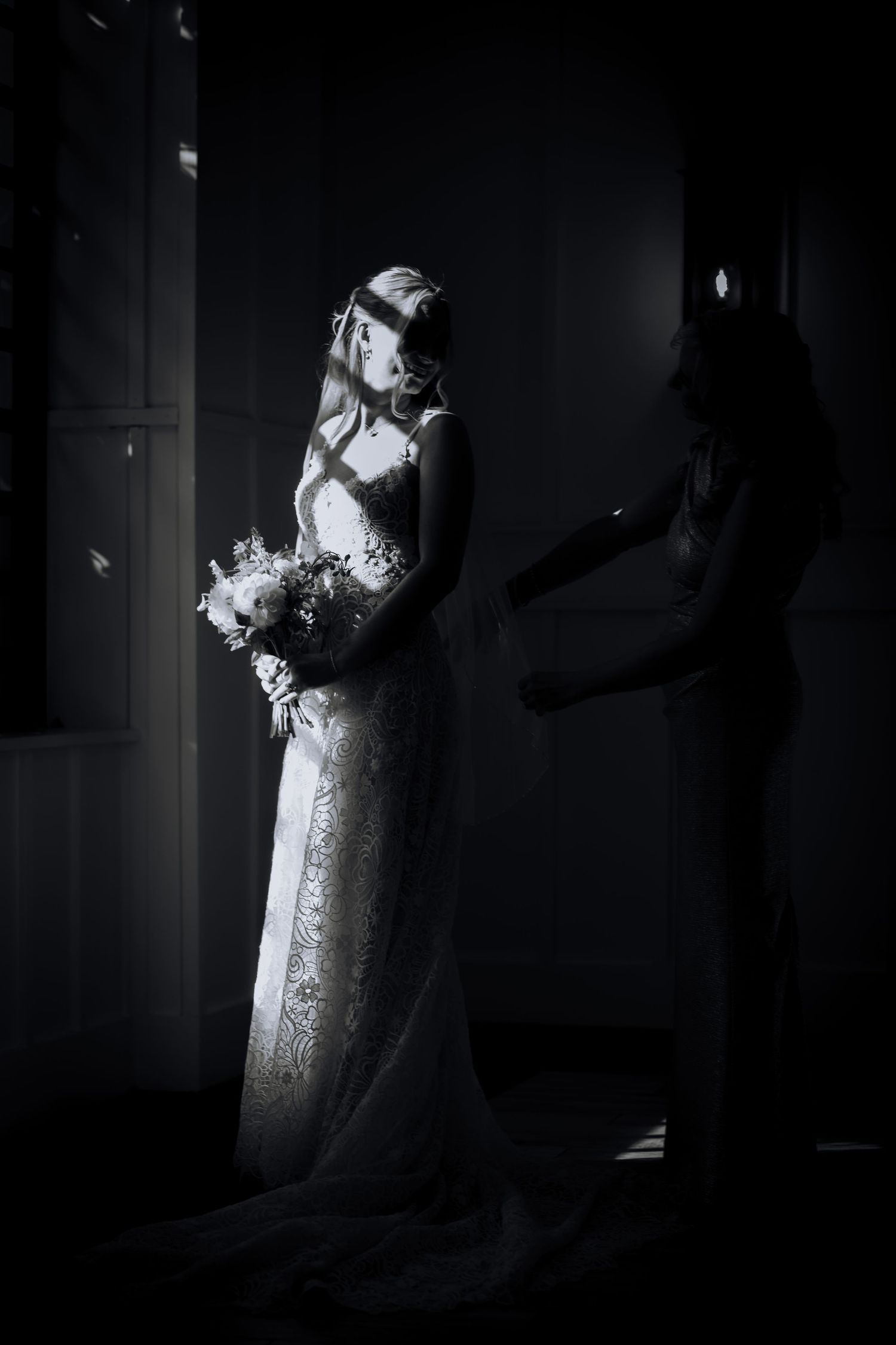 Dramatic silhouettes of a couple in wedding attire against moody lighting.