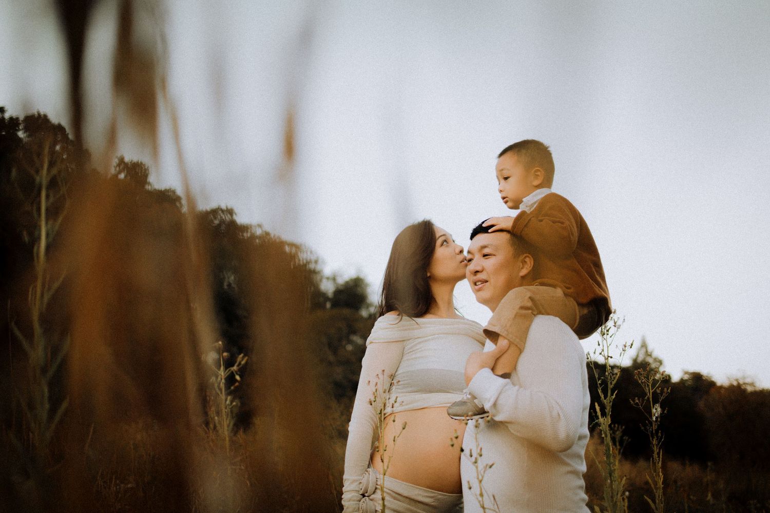 Intimate maternity photo session in a dreamy outdoor setting with soft lighting and natural surroundings.