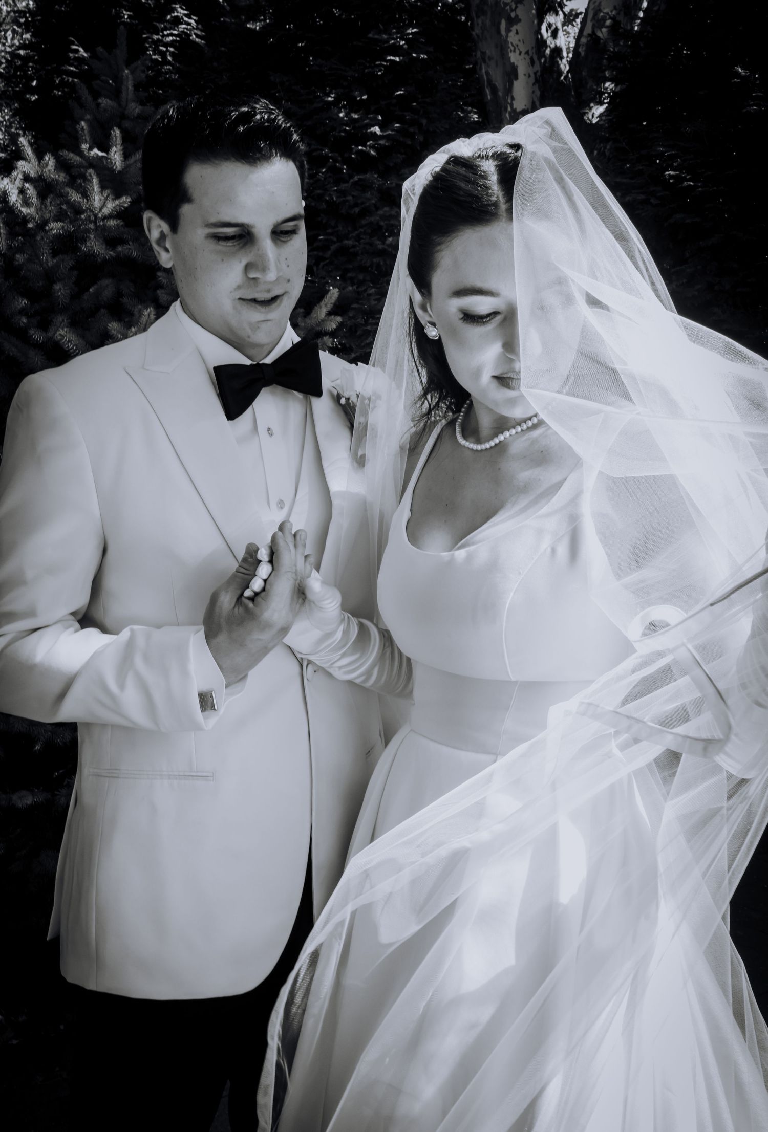 Classic black and white wedding photos showing intimate moments between a couple in formal attire.