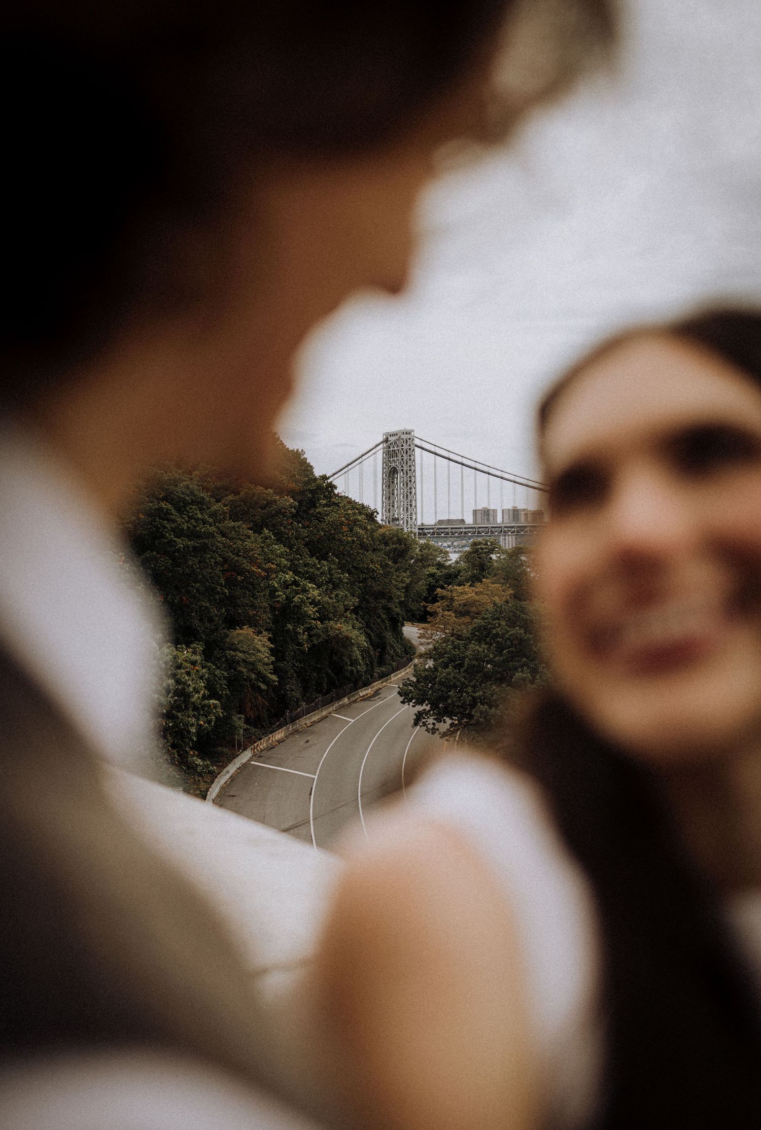 A blurred selfie perspective showing a bridge and trees in the background through multiple frames.