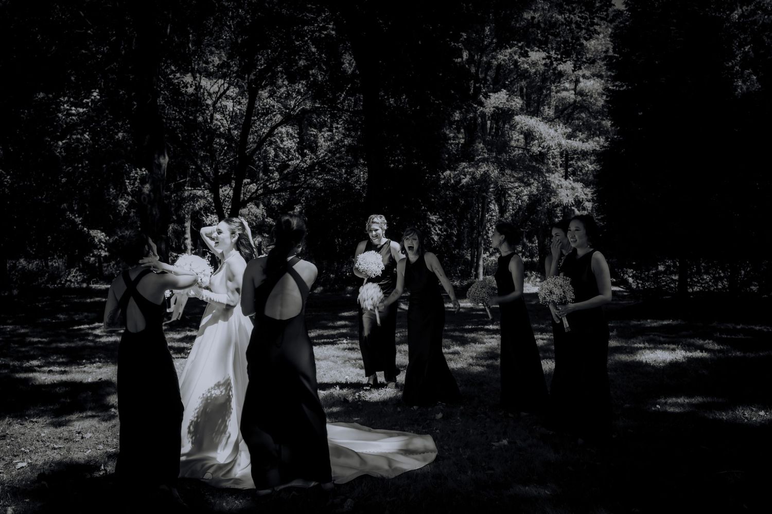 Candid black and white wedding celebration photos captured in an outdoor setting.