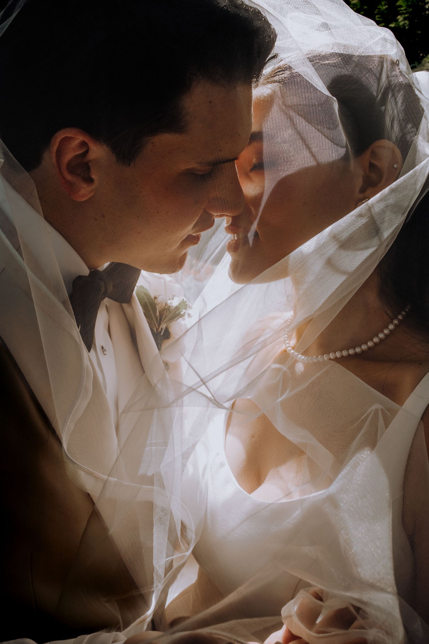 Intimate black and white wedding portrait showing delicate details of bridal attire.