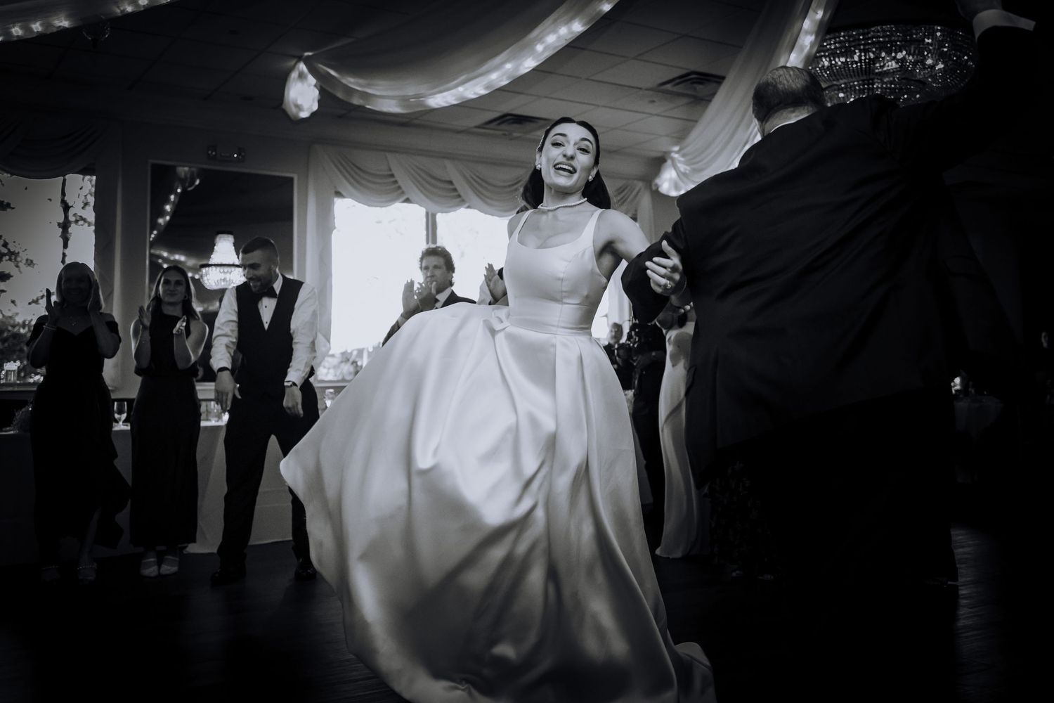 Wedding reception dance floor scene with dramatic lighting and movement.