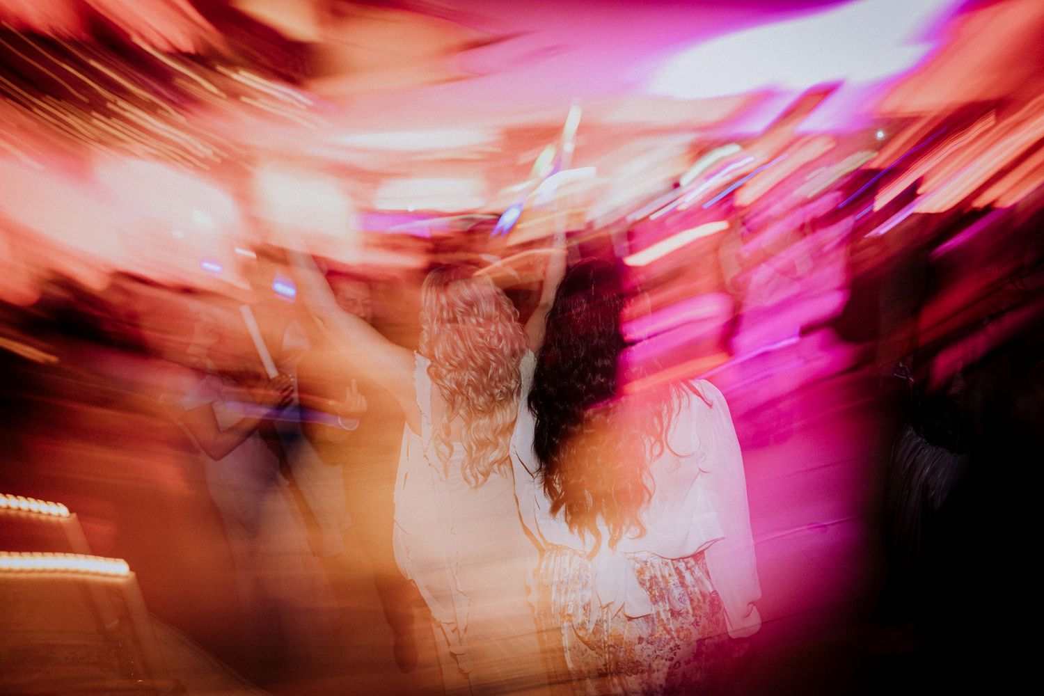 Abstract motion blur photograph with vibrant red and pink streaks creating a dynamic sense of movement.