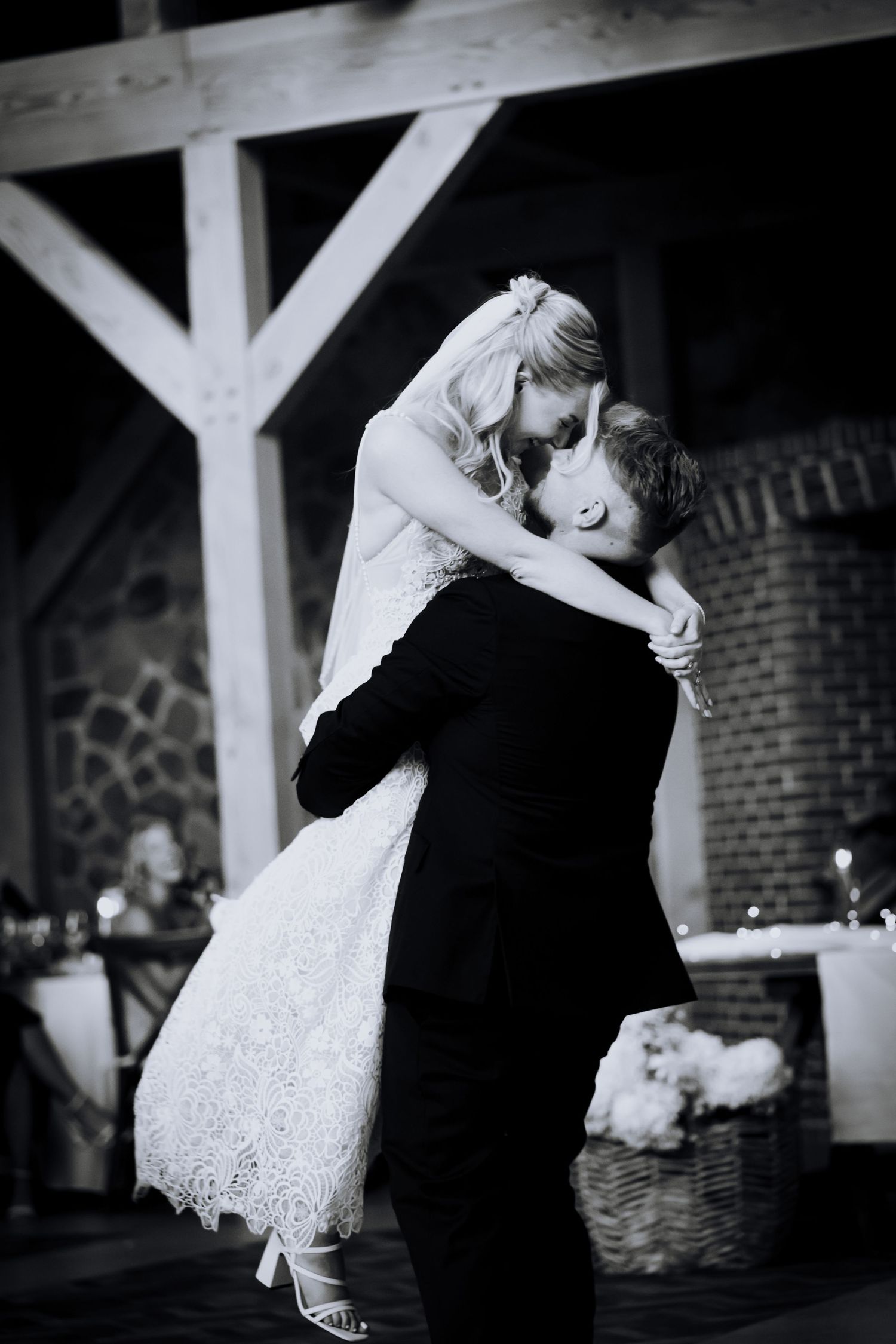 A couple dances together during their wedding reception in black and white photography.