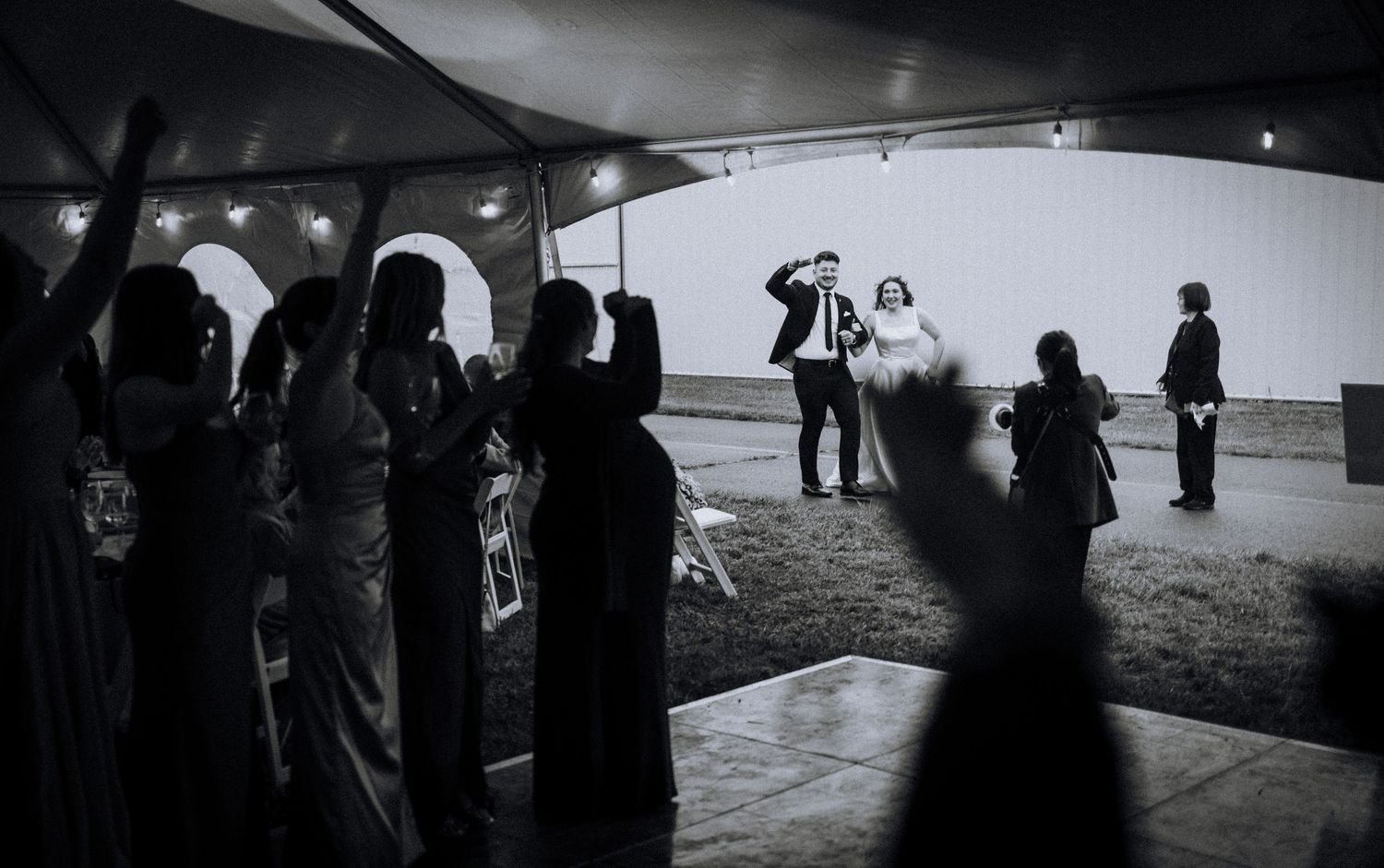 Silhouetted figures gather in a dark venue creating a moody atmospheric scene.