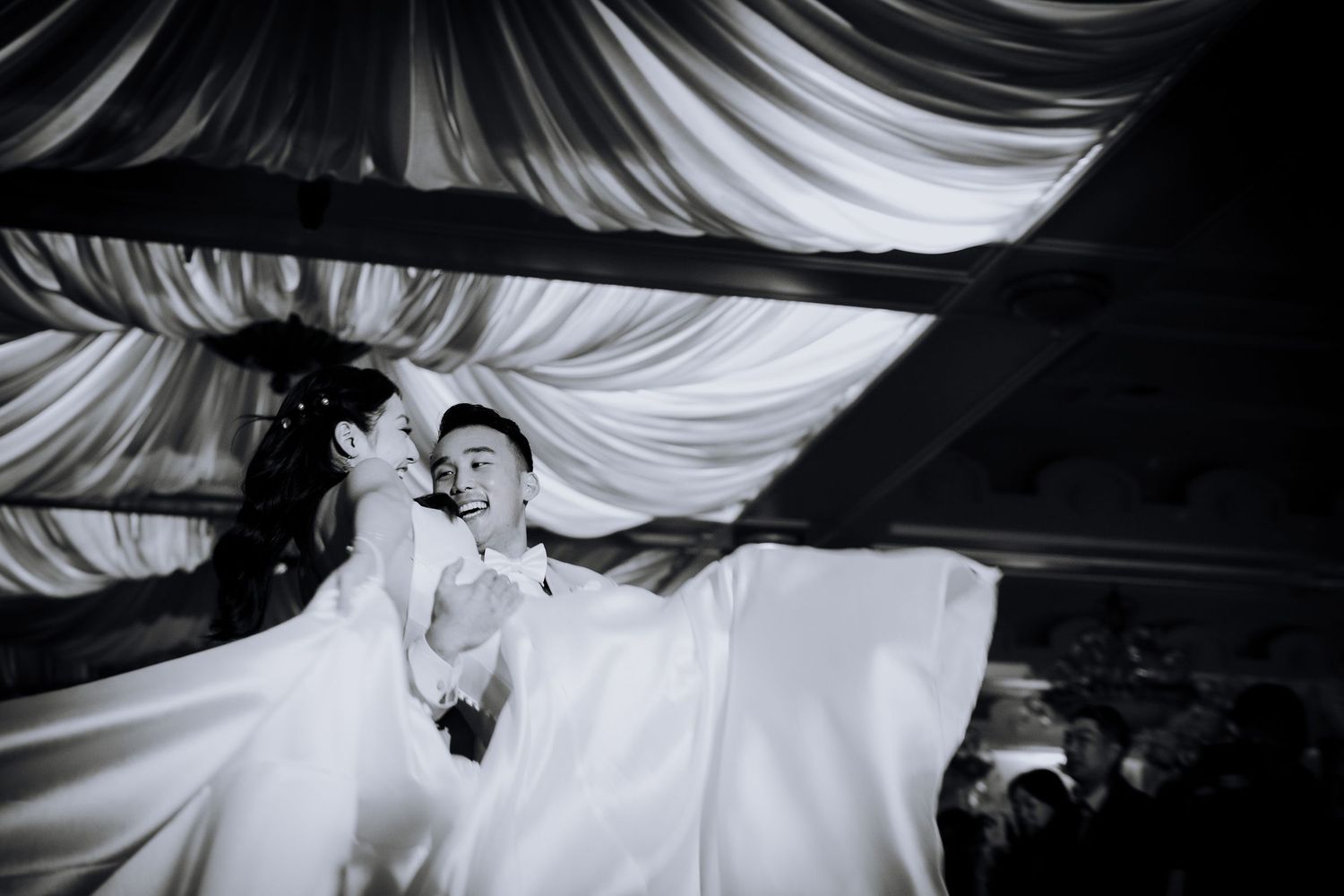 Dramatic black and white sequence showing movement and flow of white fabric in an indoor setting.