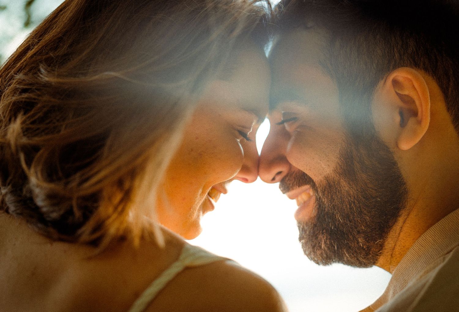 Silhouetted couple in warm backlight creating romantic atmosphere.