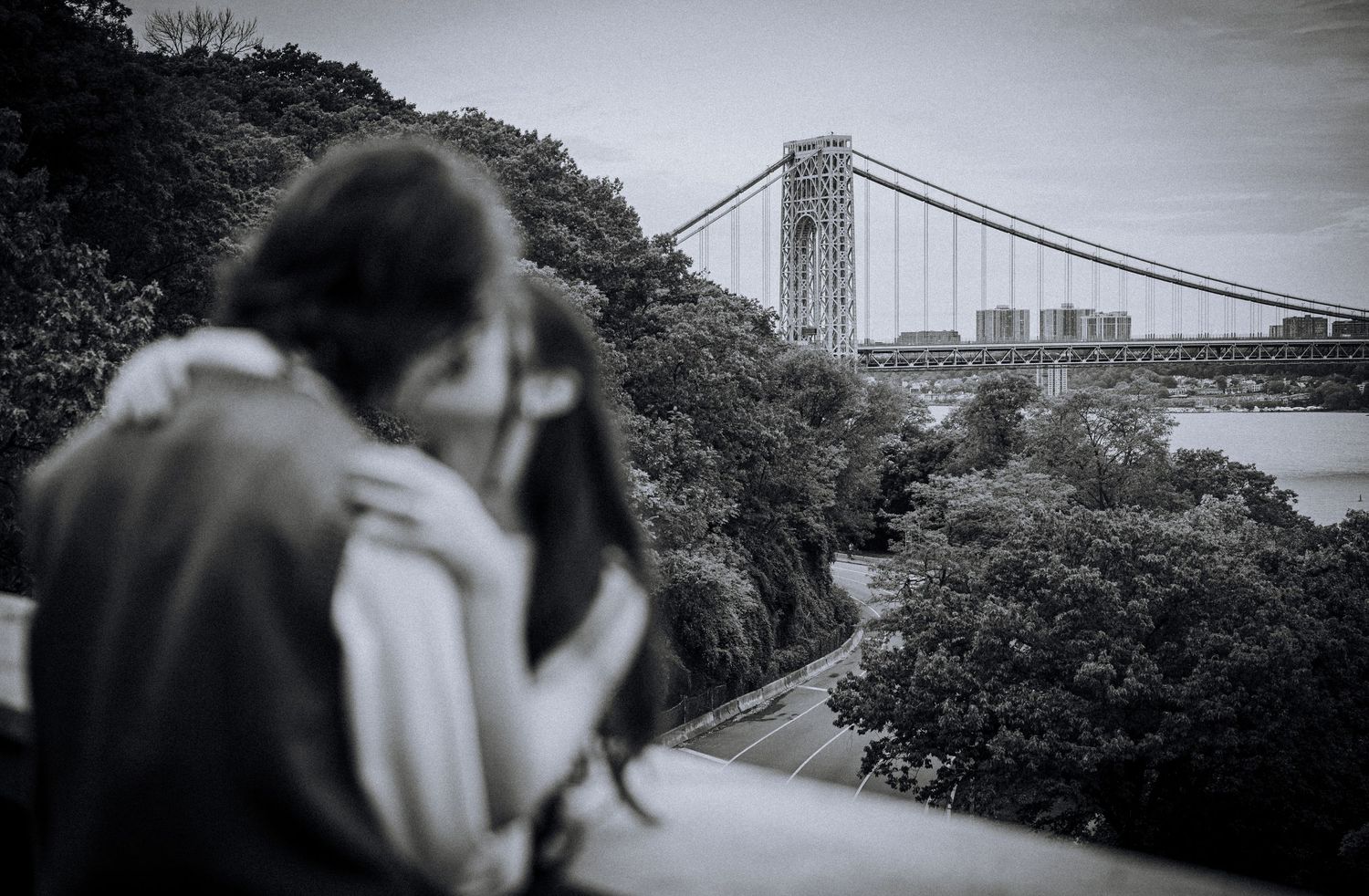 Panoramic view of the George Washington Bridge with couple in soft focus foreground.