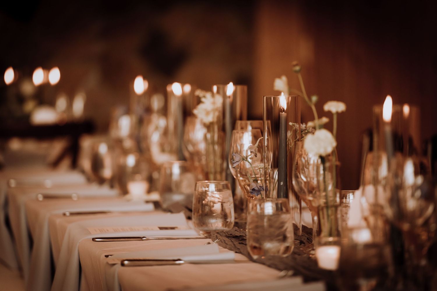 Candlelit table settings create a romantic ambiance at an evening wedding reception.