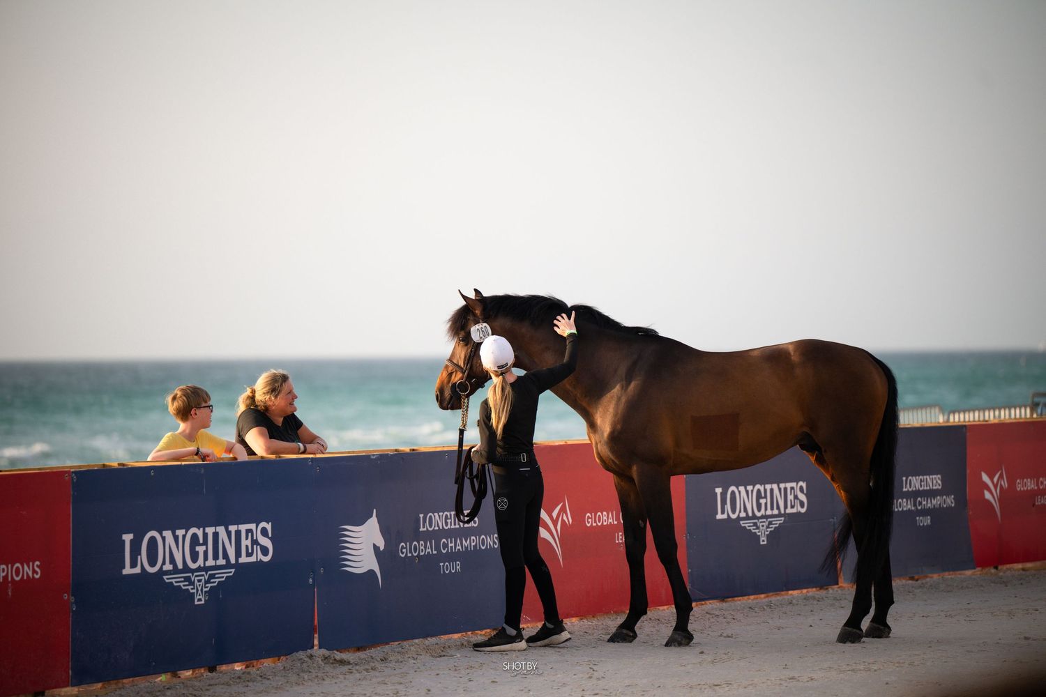 A horse and rider perform at an equestrian competition with Longines sponsorship banners visible in the background.