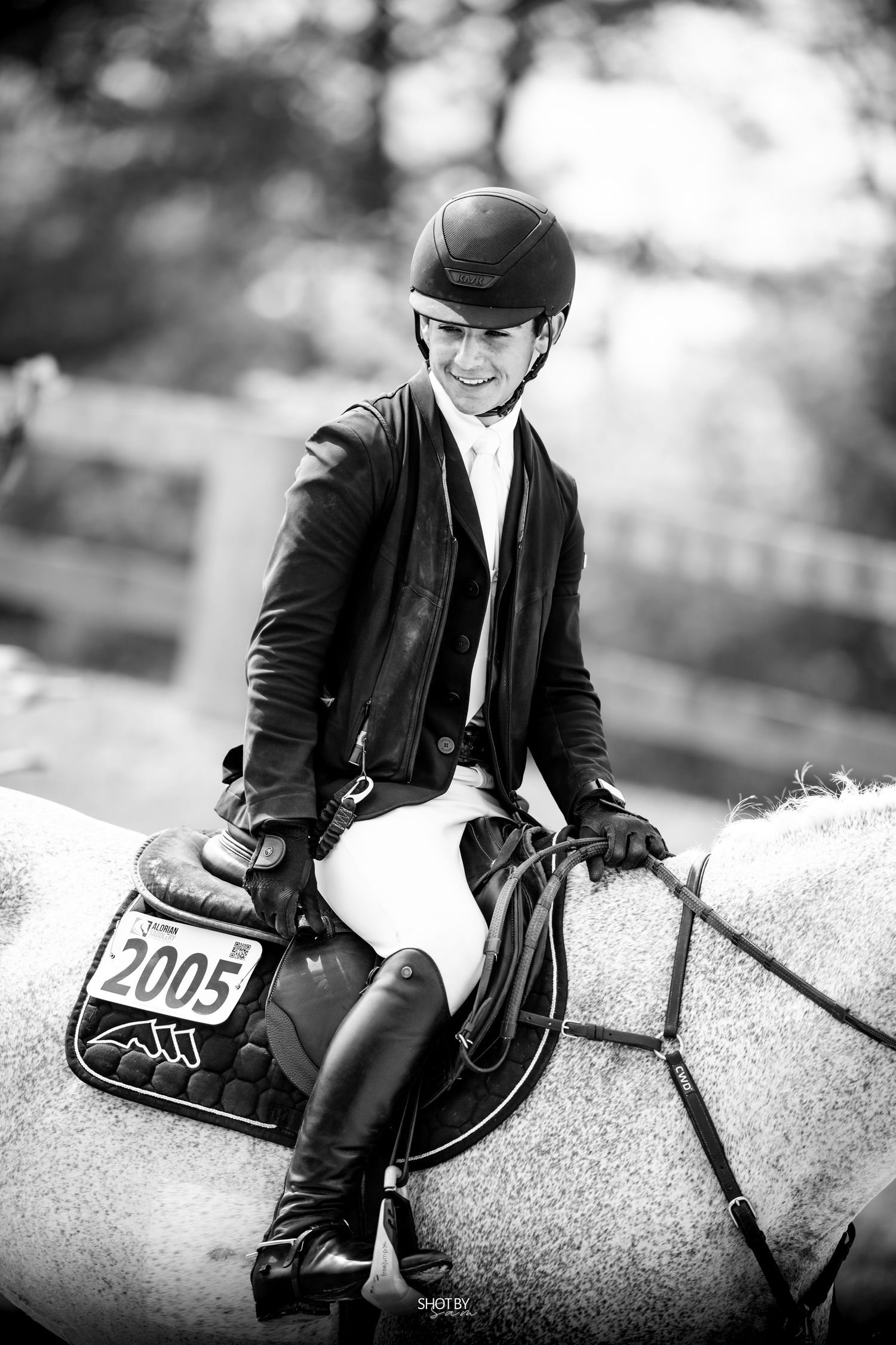 Rider in black jacket on dappled gray horse with competition number 2005.